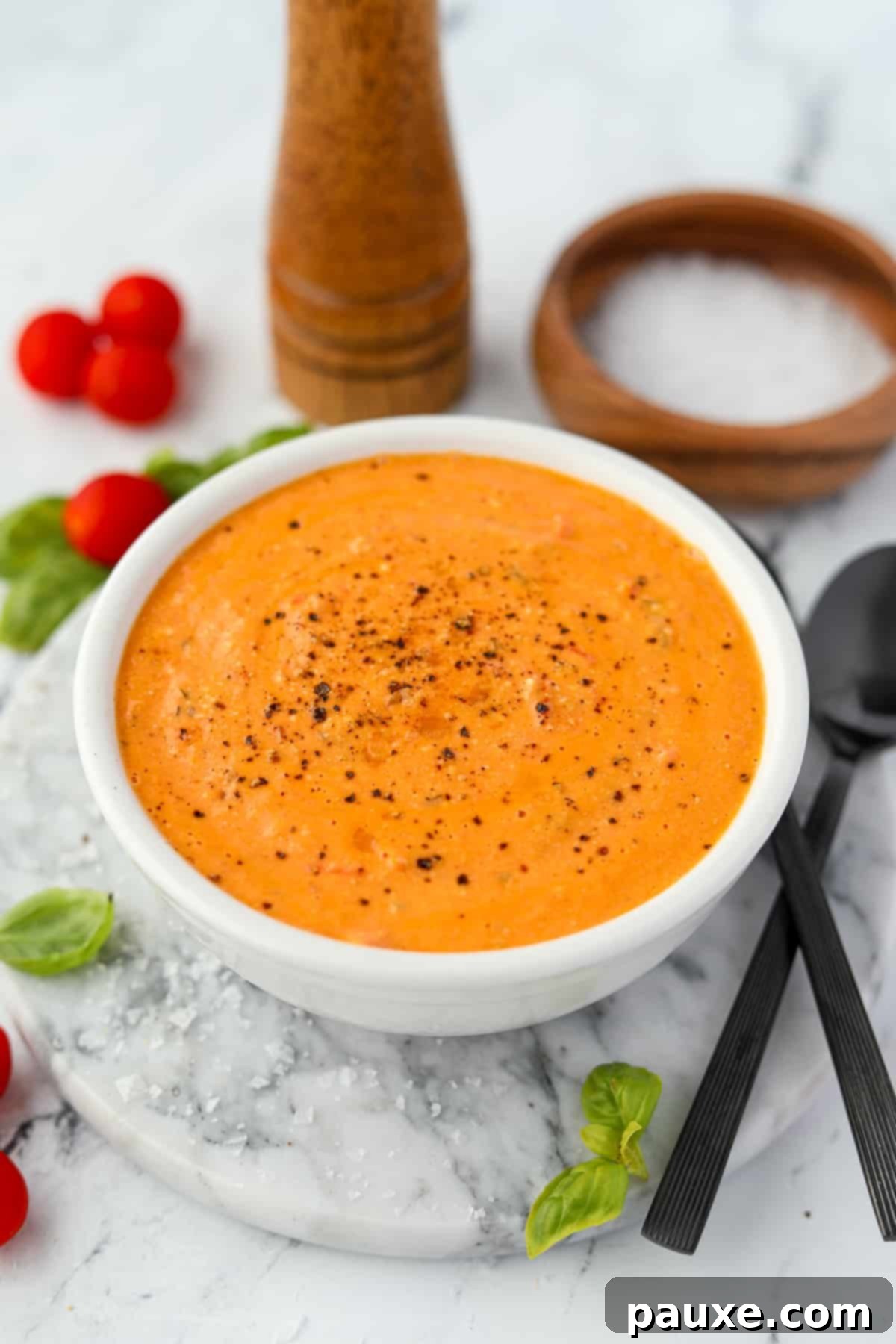 Roasted Feta Tomato Soup 5 A beautifully presented bowl of creamy tomato soup resting on a elegant marble round, inviting a comforting meal.