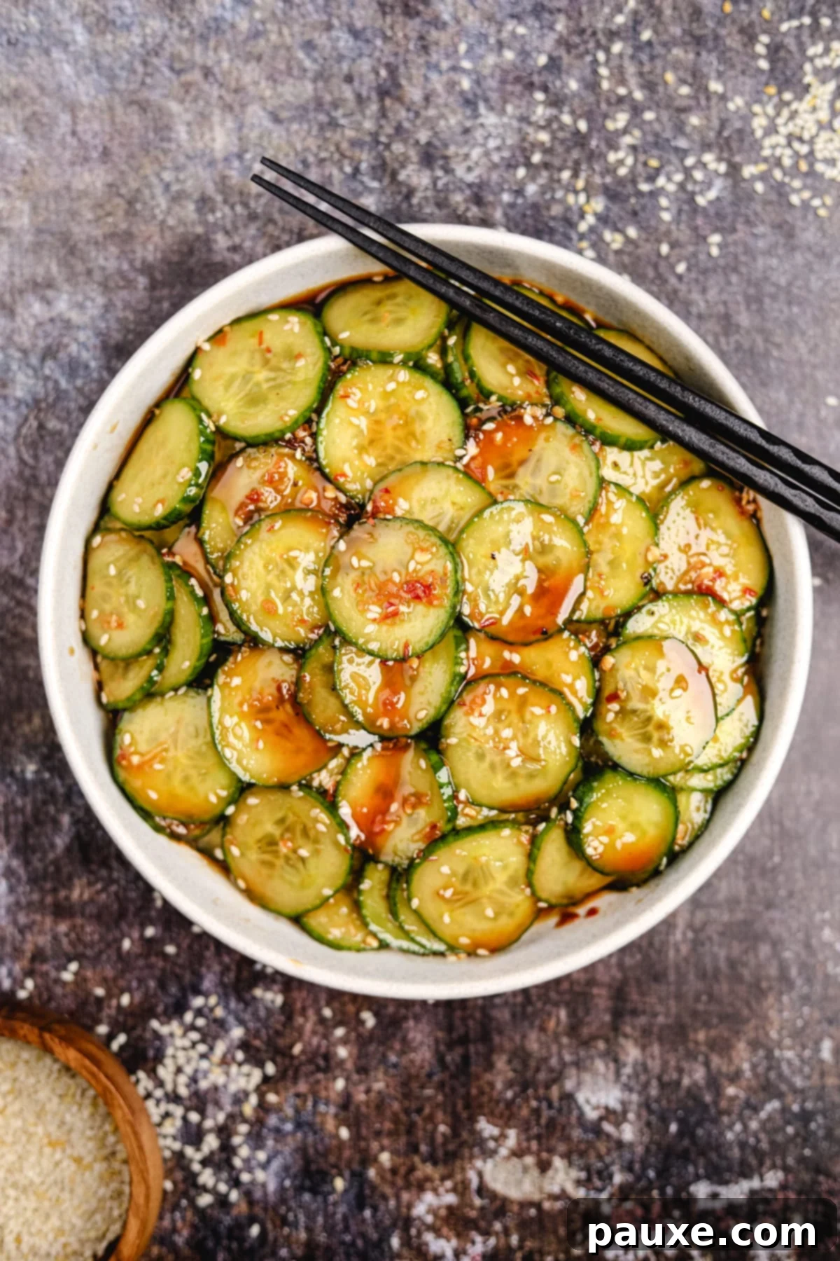 Chili Garlic Cucumber Crunch 5 A bowl of cucumber salad with black chopsticks in the top right corner.