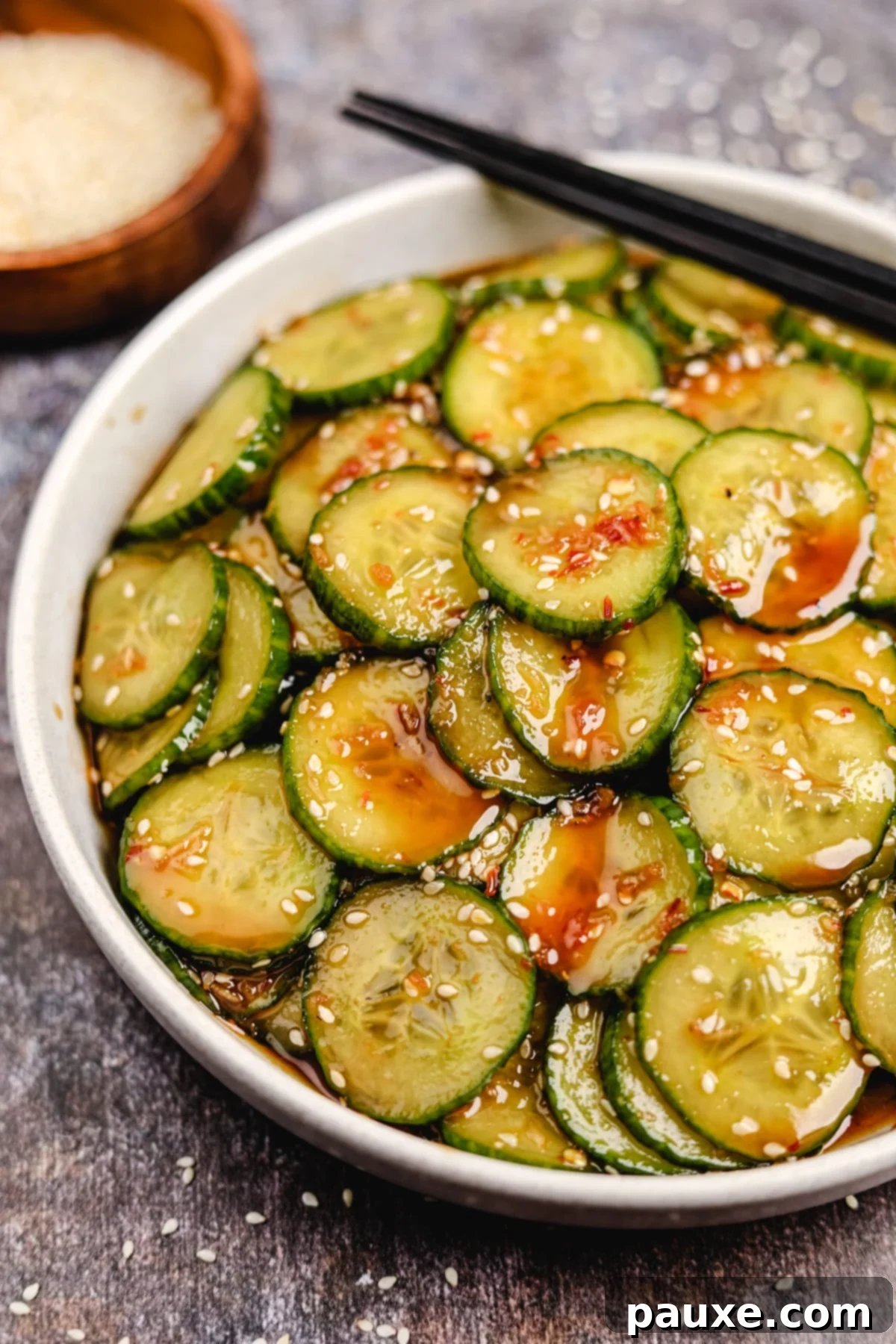 Chili Garlic Cucumber Crunch 6 A bowl of cucumber salad glazed in a brownish-red dressing.