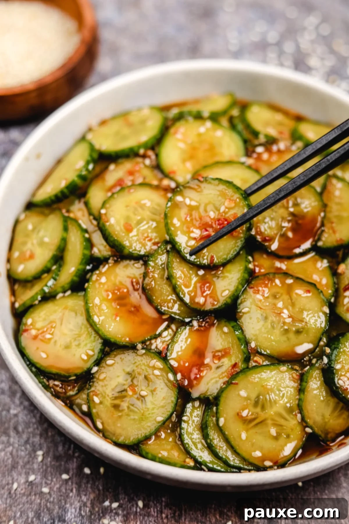 Chili Garlic Cucumber Crunch 7 Chopsticks taking several cucumber slices from a bowl.