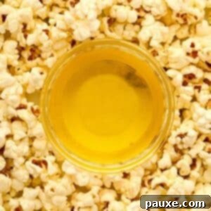 Golden Popcorn Topping 9 A small bowl of clarified butter with popcorn all around the bowl.
