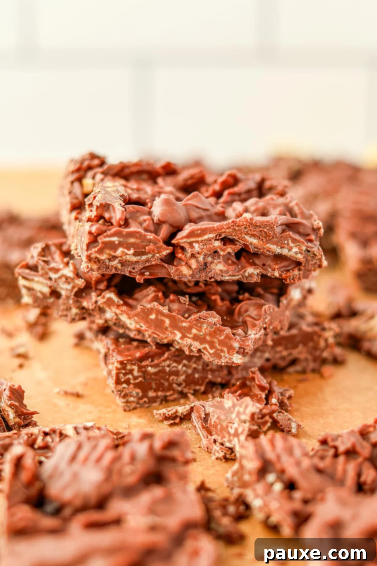 Salty Sweet Chocolate Crunch Bark 2 A stack of chocolate bark on a sheet of parchment paper, showcasing the sweet and salty delight.