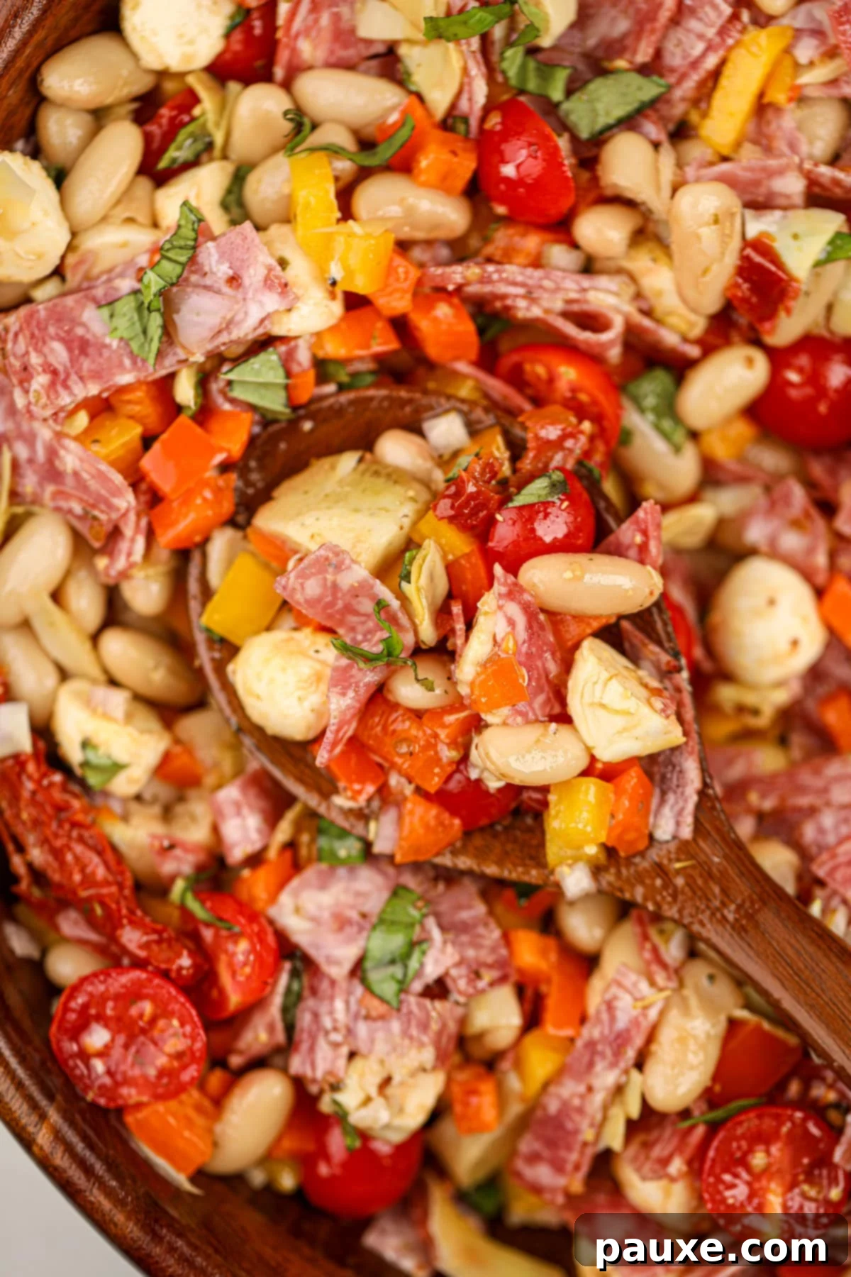 Hearty Italian Bean Medley 2 A wooden spoon taking a portion of bean salad from a bowl.