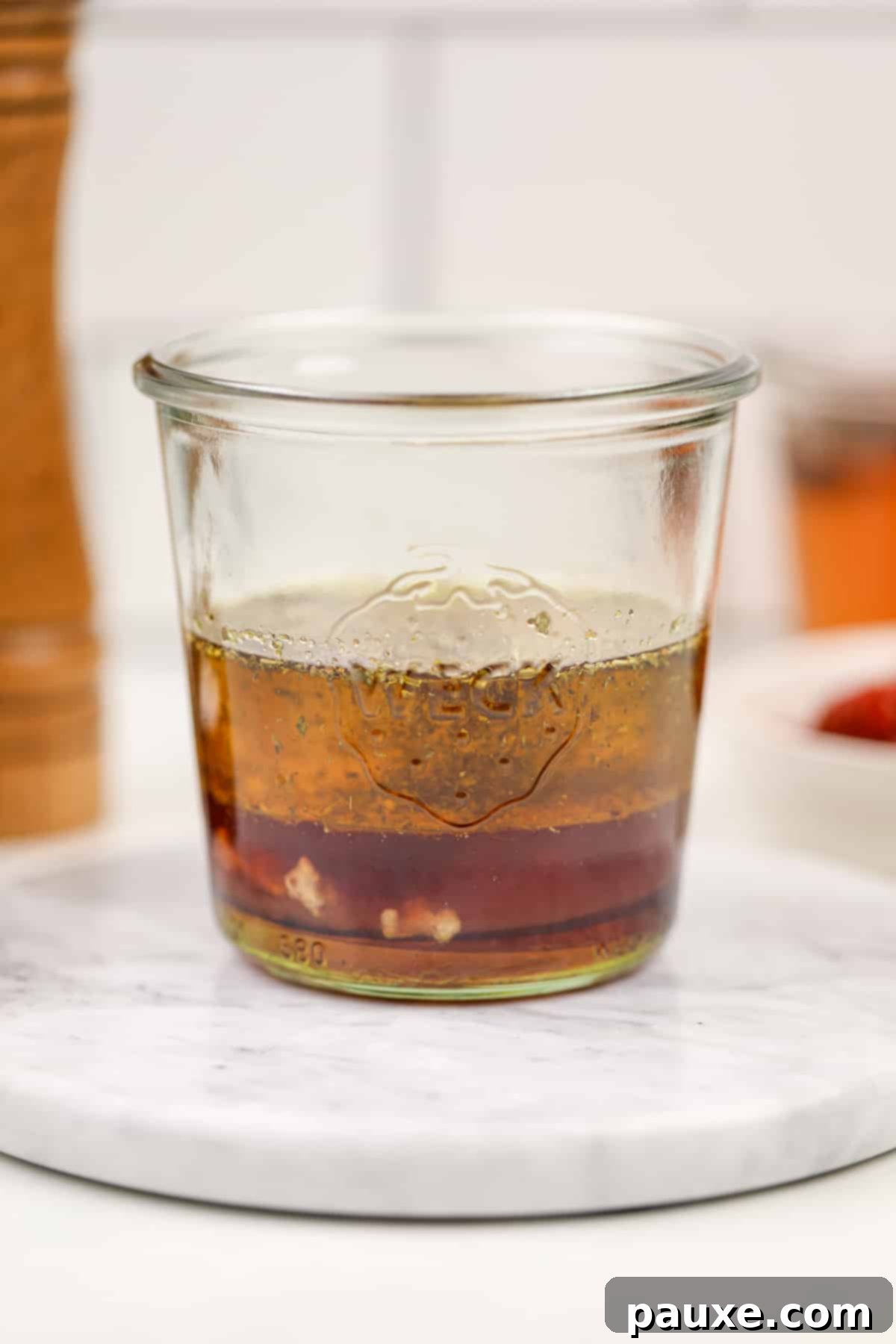 Mediterranean Sunset Vinaigrette 4 A glass jar featuring layers of oil and vinegar.