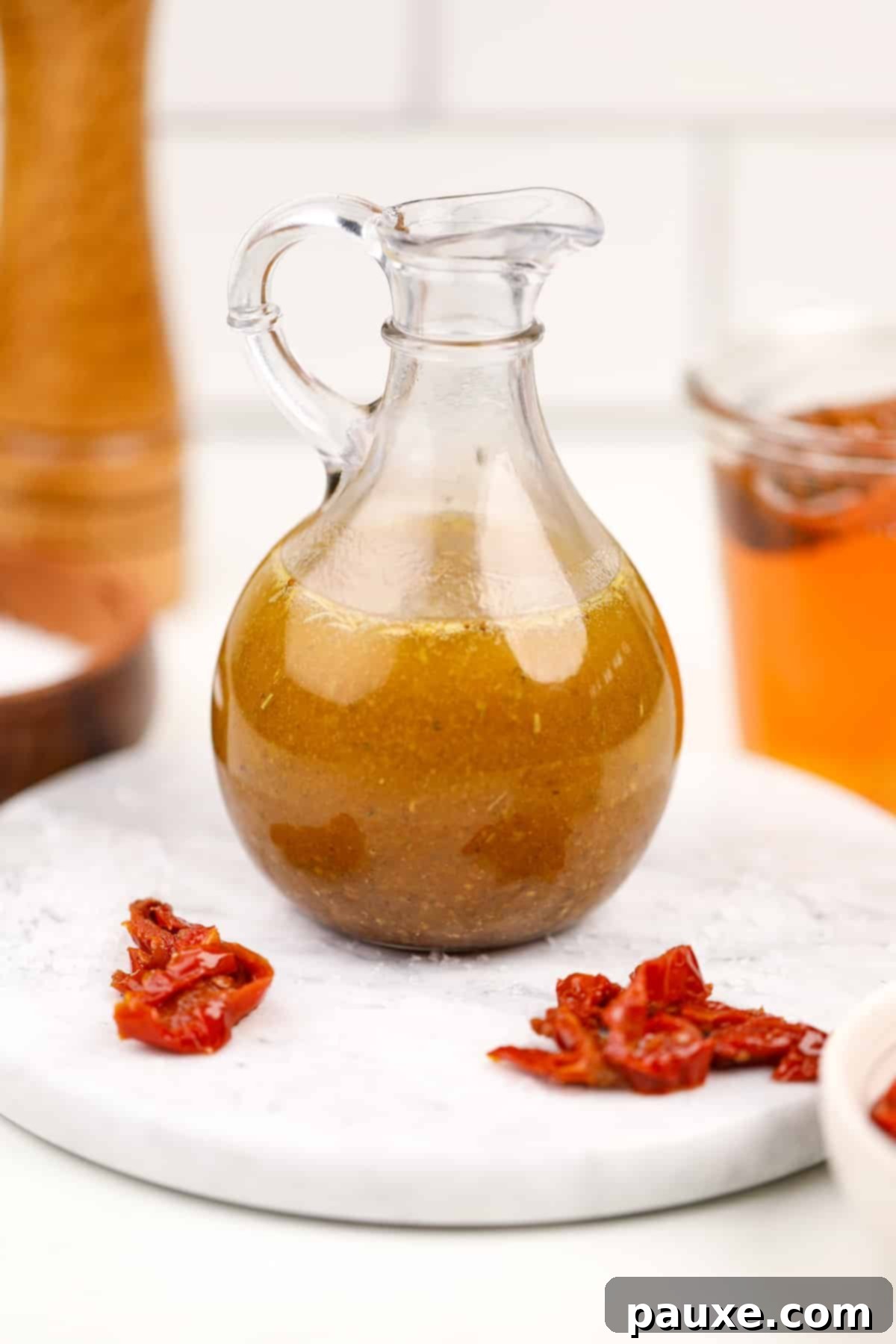 Mediterranean Sunset Vinaigrette 9 A cruet filled with homemade dressing; sundried tomatoes on the marble around it.