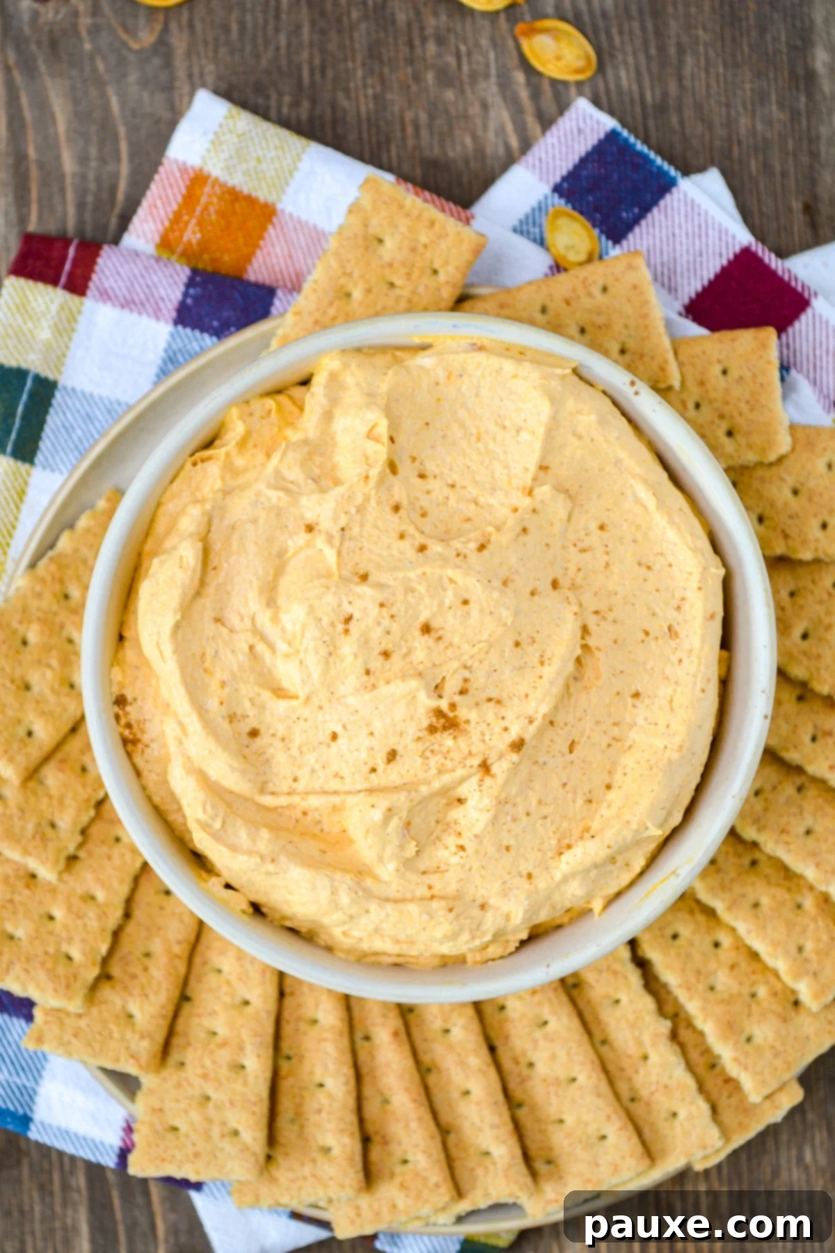 A bowl of pumpkin fluff dip, surrounded by graham crackers.