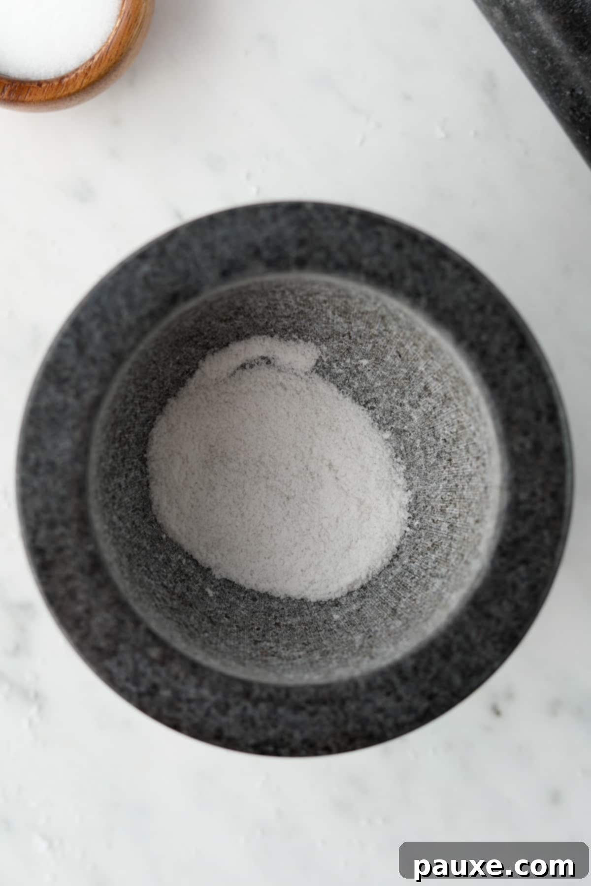 Artisan Popcorn Dust 5 The bowl of a mortar filled with powdery ground salt.