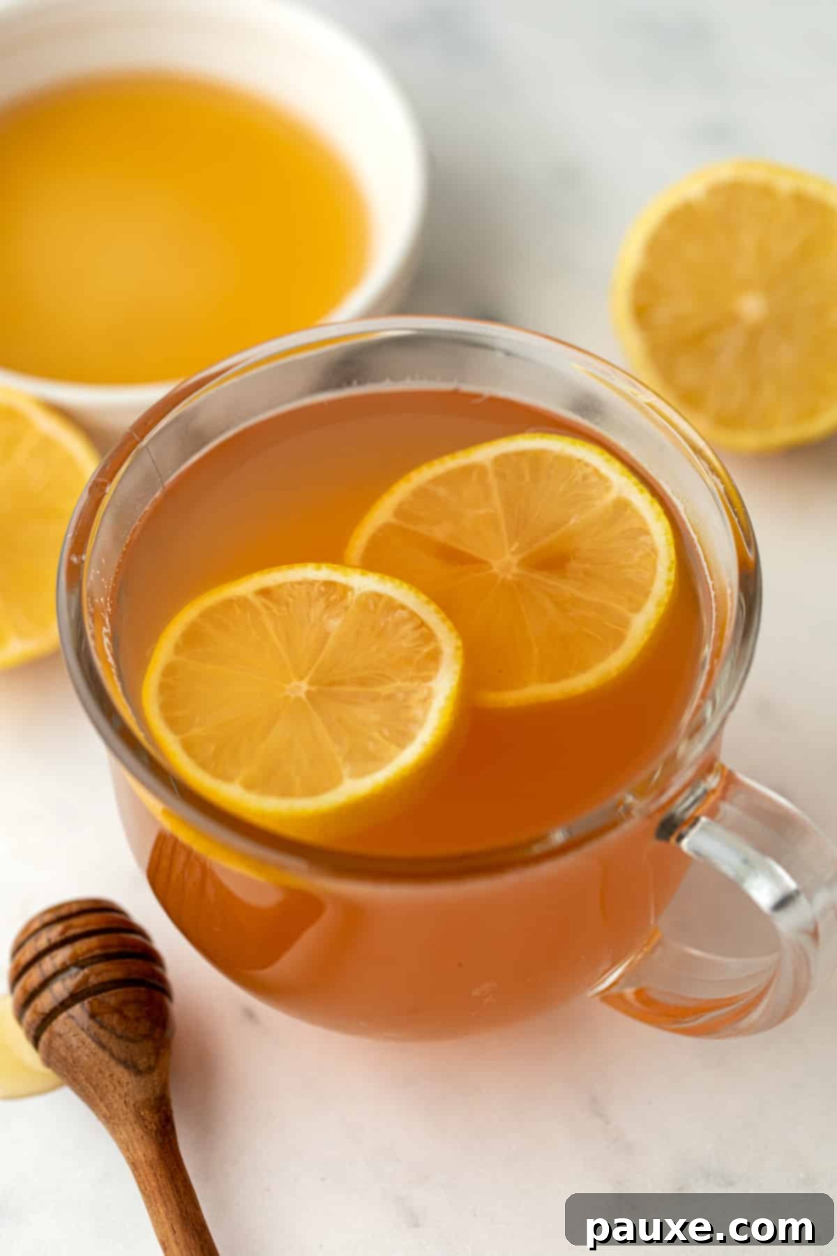 A mug of tea garnished with slices of fresh lemon.