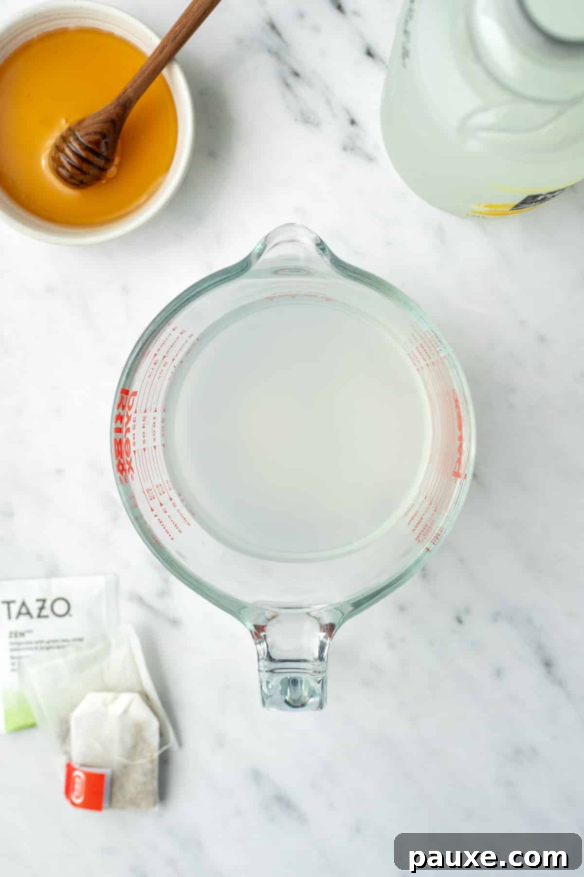 A measuring cup filled with a mix of lemonade and water.