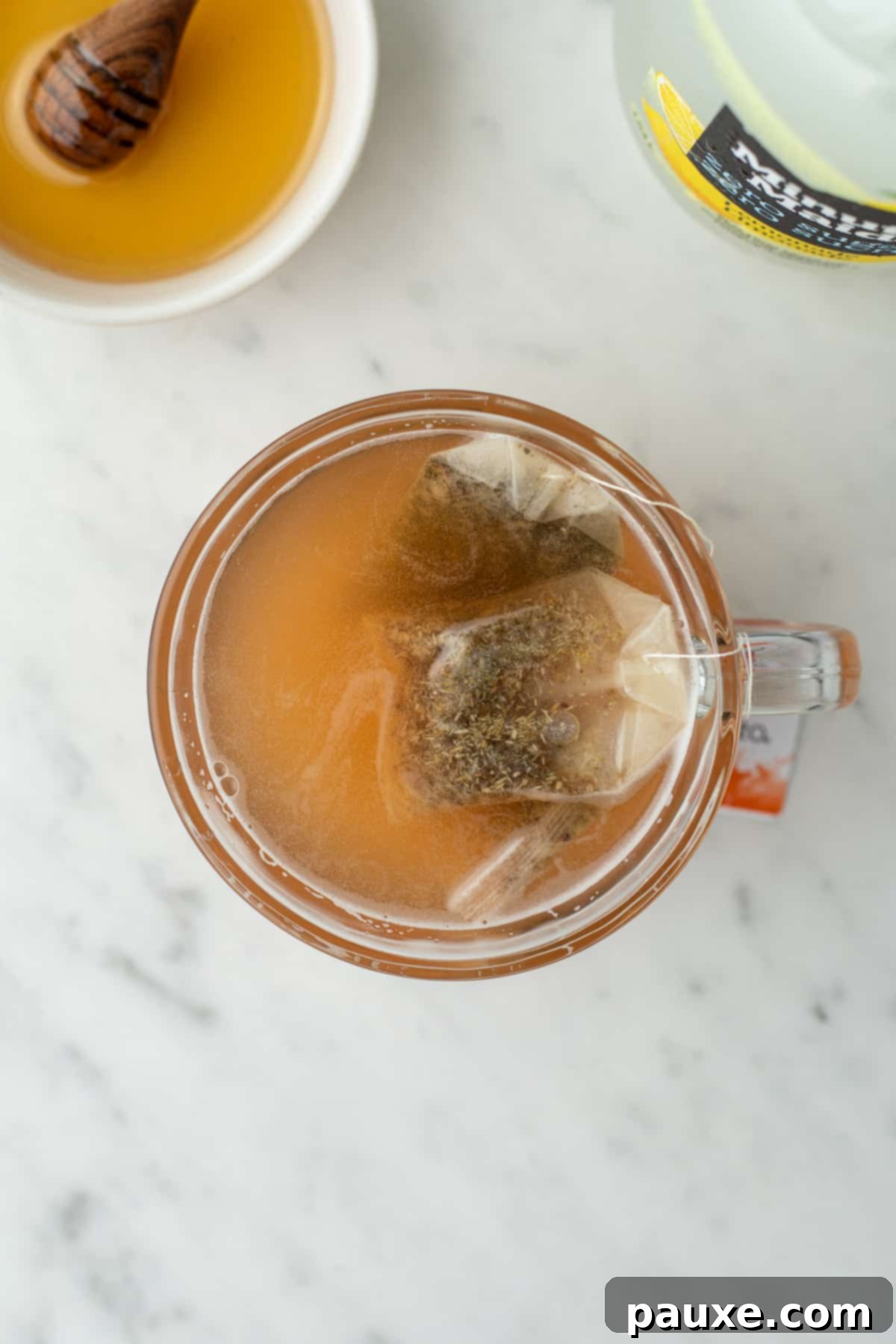 Steeped tea that has an orange-ish hue in a glass mug.