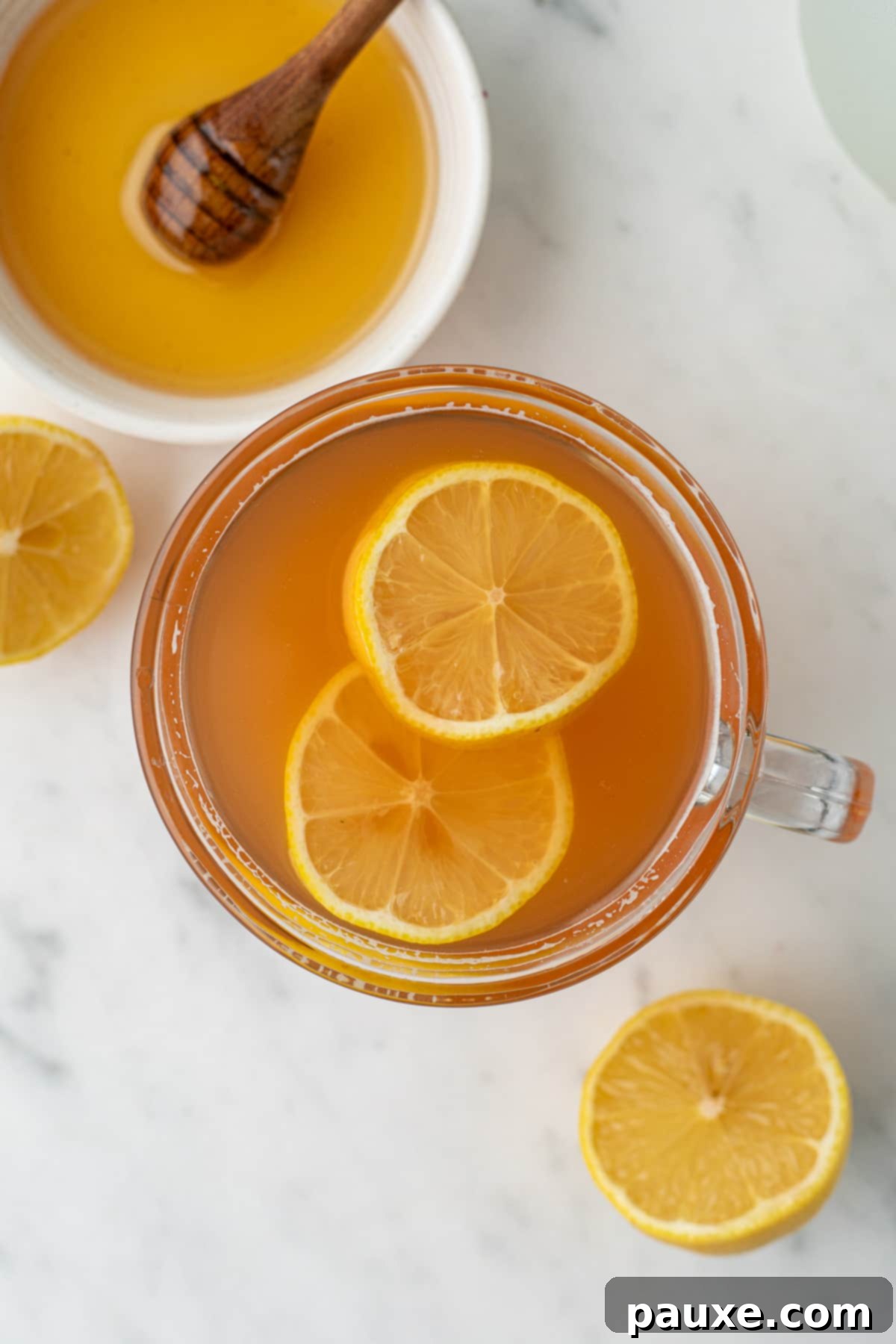 A mug of honey citrus mint tea garnished with lemon slices.