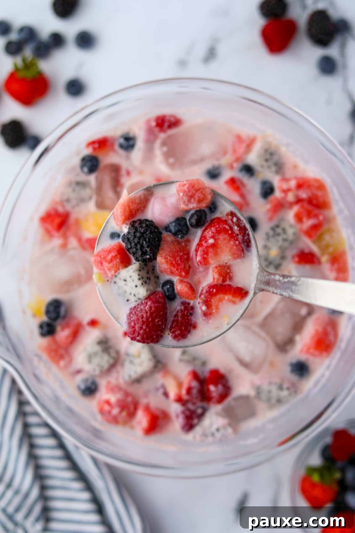 A punch bowl with a ladle showing a scoop of fruit punch.