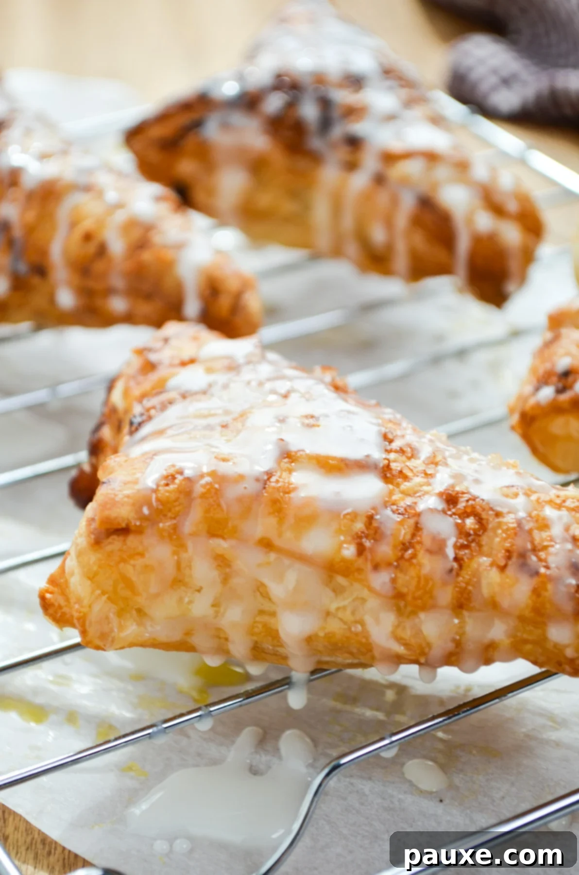 Golden Air Fried Apple Delights 3 Freshly baked air fryer apple turnovers cooling on a wire rack, beautifully drizzled with a simple, sweet glaze.