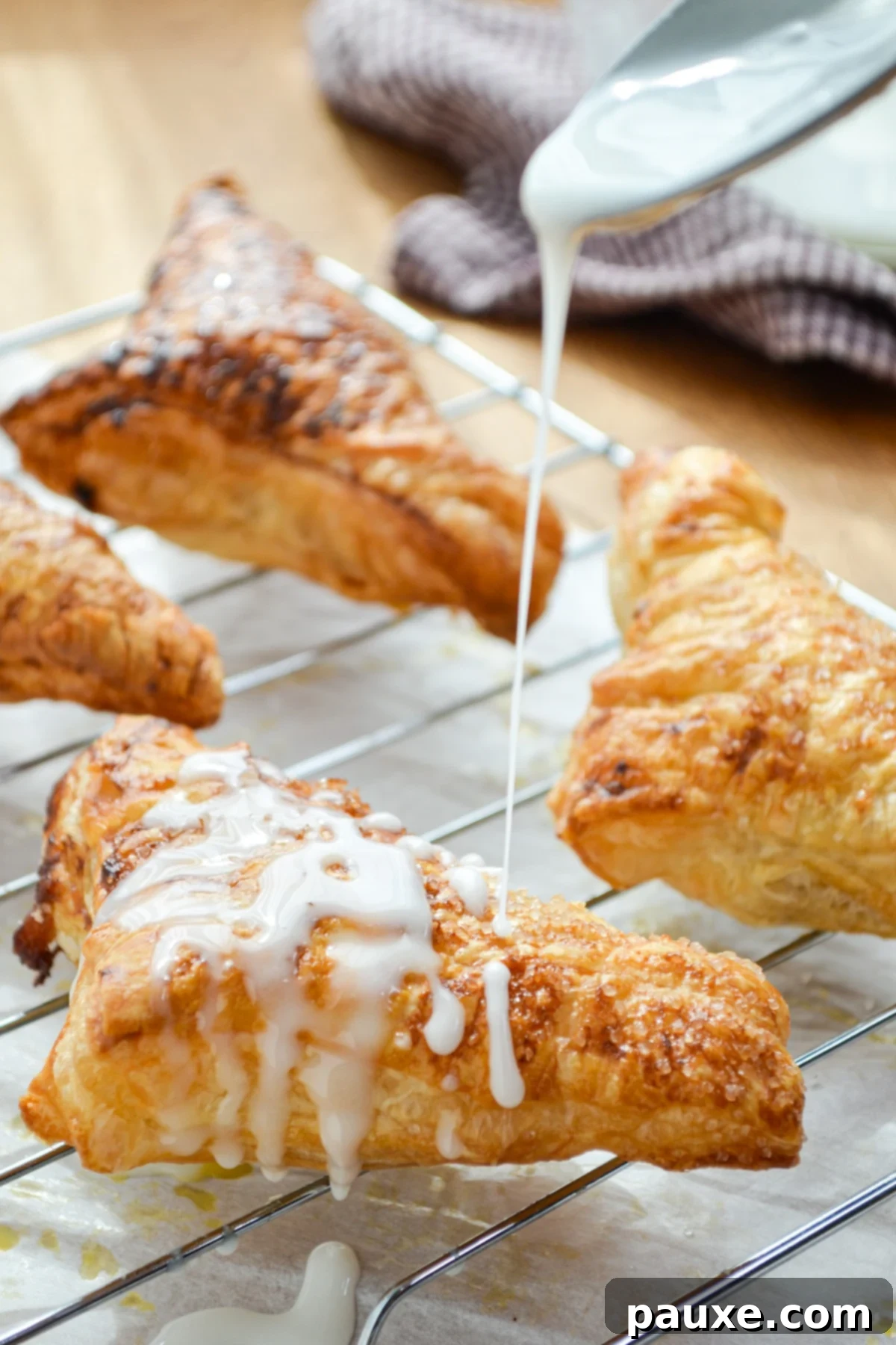 Golden Air Fried Apple Delights 9 A warm, freshly baked apple turnover being gracefully drizzled with a rich, homemade vanilla glaze.