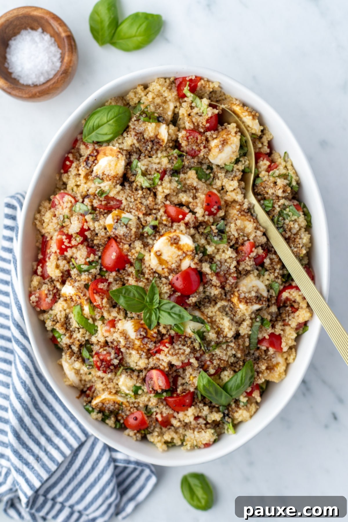 Vibrant Quinoa Caprese 2 A bowl of quinoa salad garnished with fresh basil and a drizzle of balsamic glaze.