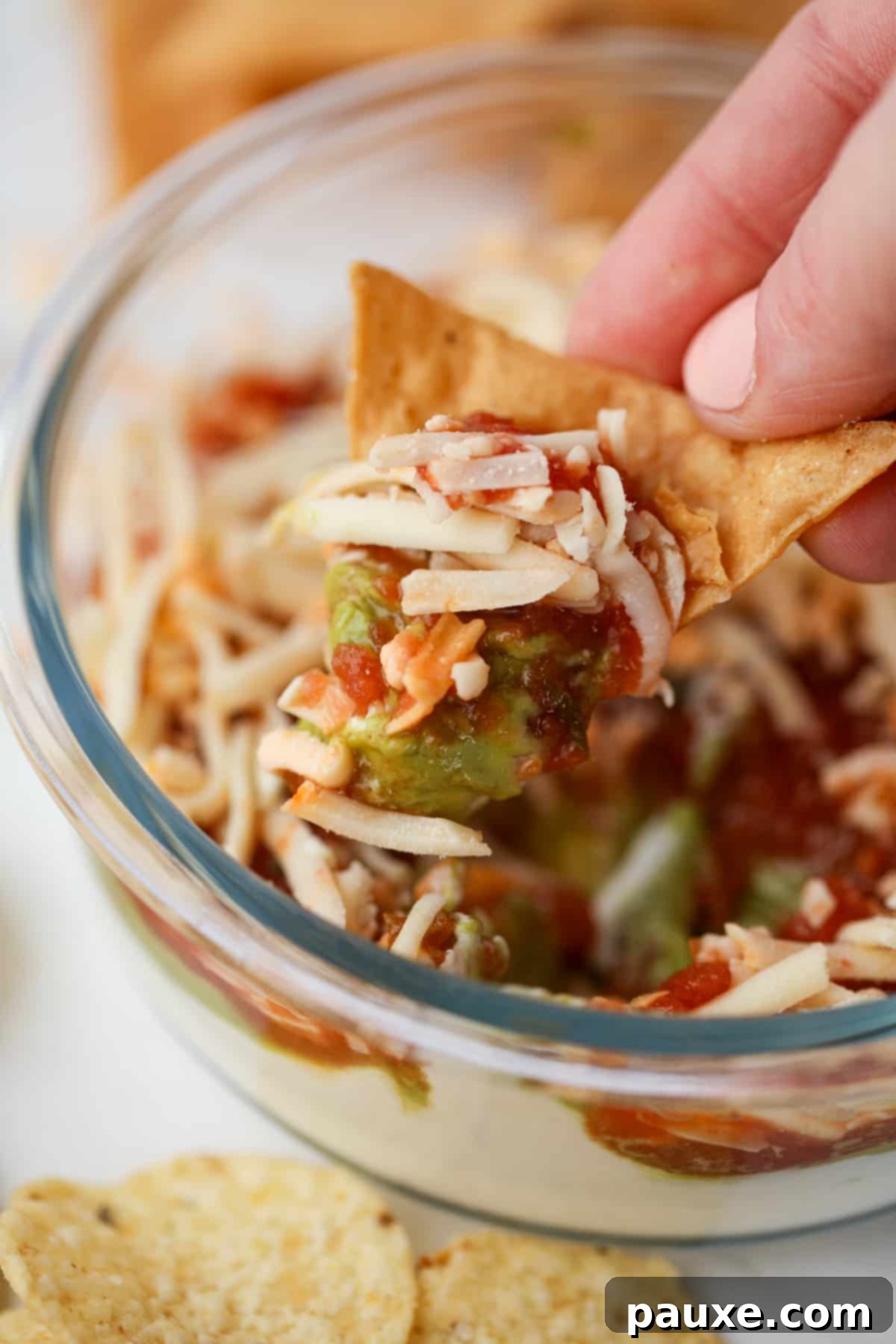 Power-Packed Greek Yogurt Dip 2 Dipping a tortilla chip into a cheese and salsa based dip.