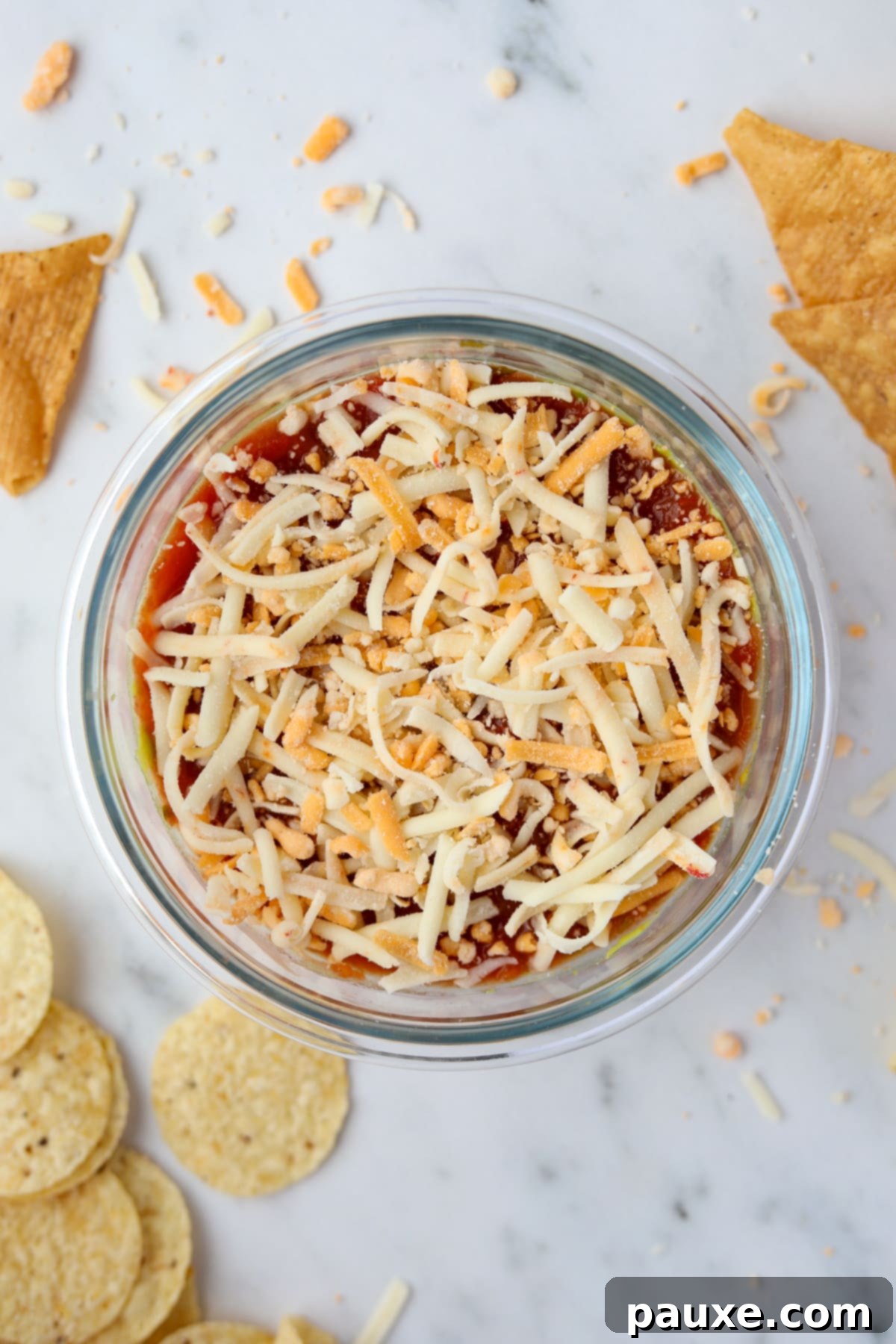 Power-Packed Greek Yogurt Dip 5 A small bowl filled with a single serving dip featuring salsa and shredded cheese.