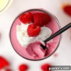 Creamy Greek Yogurt Delight 10 A small parfait glass filled with greek yogurt jello mousse, topped with whipped cream and raspberries.