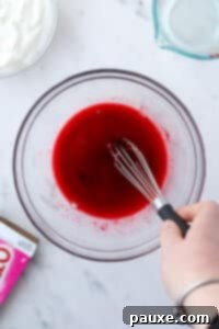 Creamy Greek Yogurt Delight 11 Whisking powdered jello into water in a large bowl.