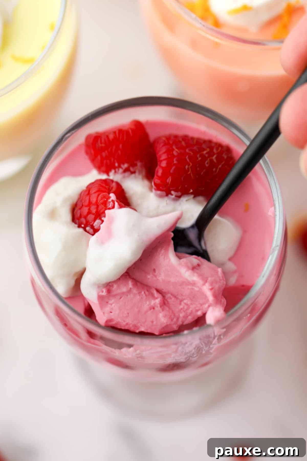 Creamy Greek Yogurt Delight 9 Taking a spoonful of yogurt mousse from a parfait glass.