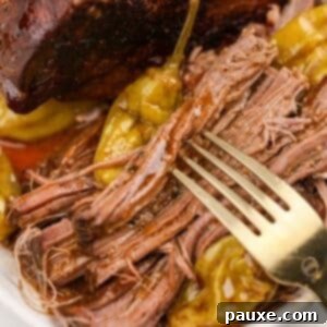 A fork spearing shreds of pot roast covered in juices.