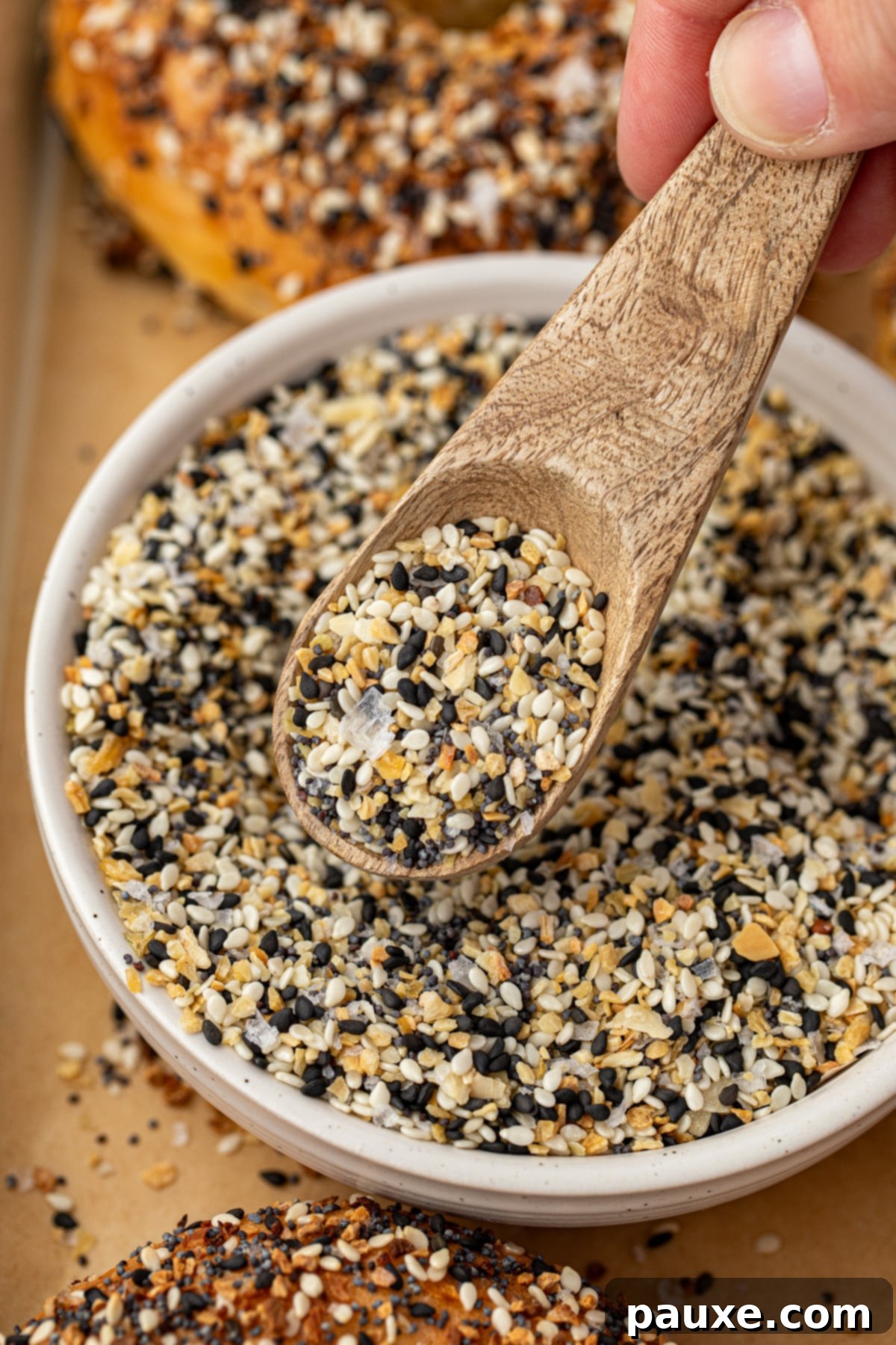 The Ultimate Seed & Spice Blend 6 A small spoon taking everything bagel seasoning from a bowl.