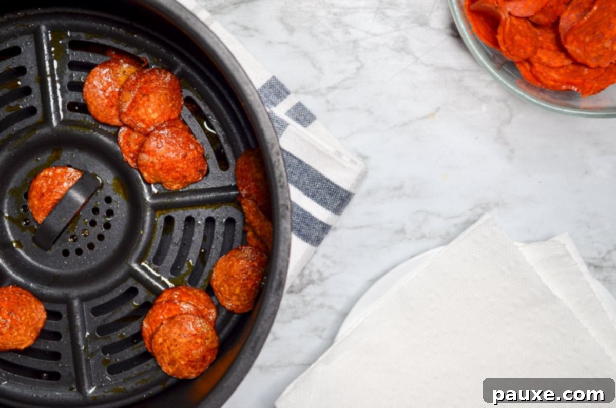 Air Fried Crispy Pepperoni 7 Air fryer pepperoni chips, fully cooked and ready to be drained on paper towels.