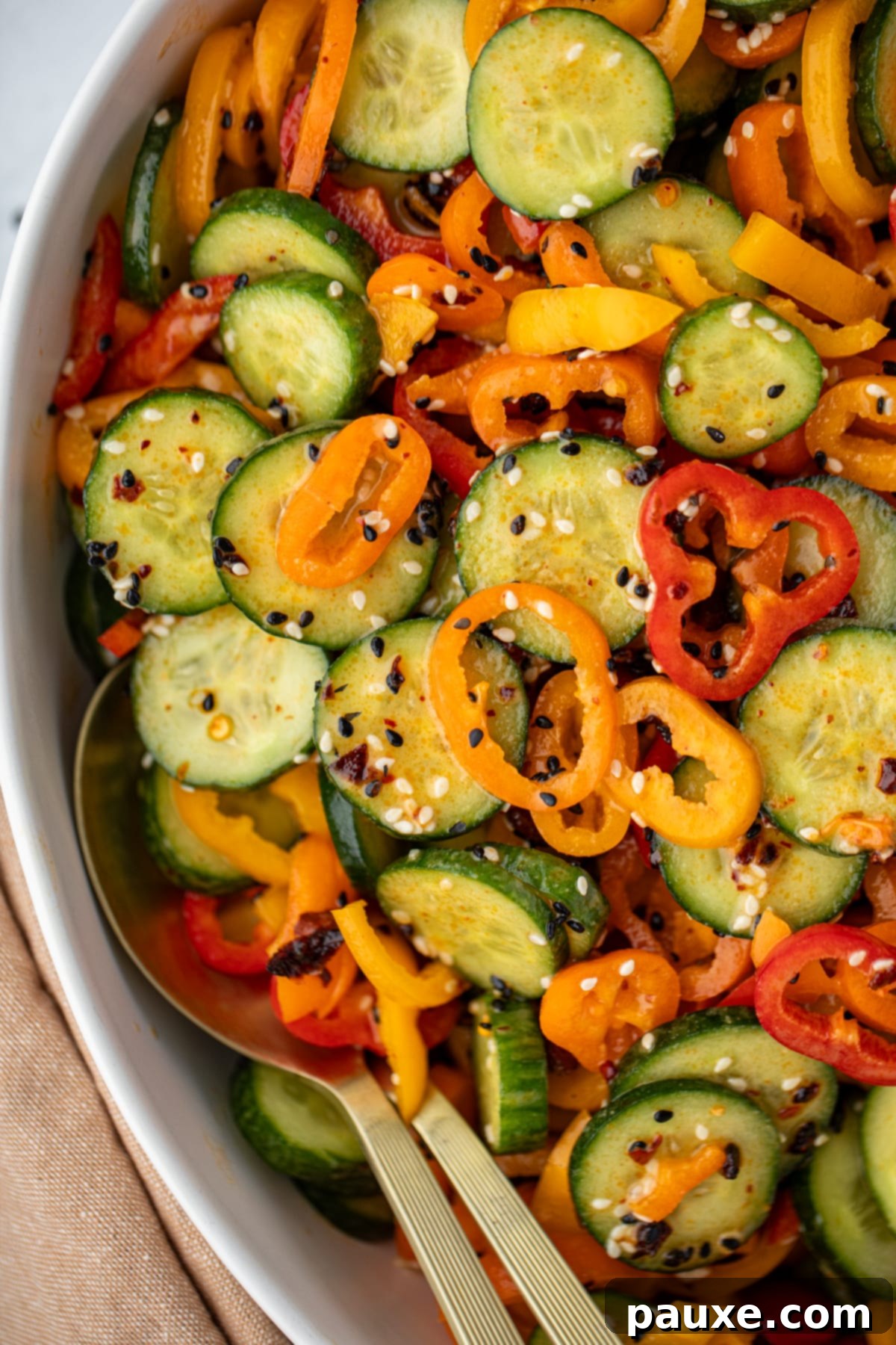 A salad bowl filled with sliced bell pepper and cucumber.