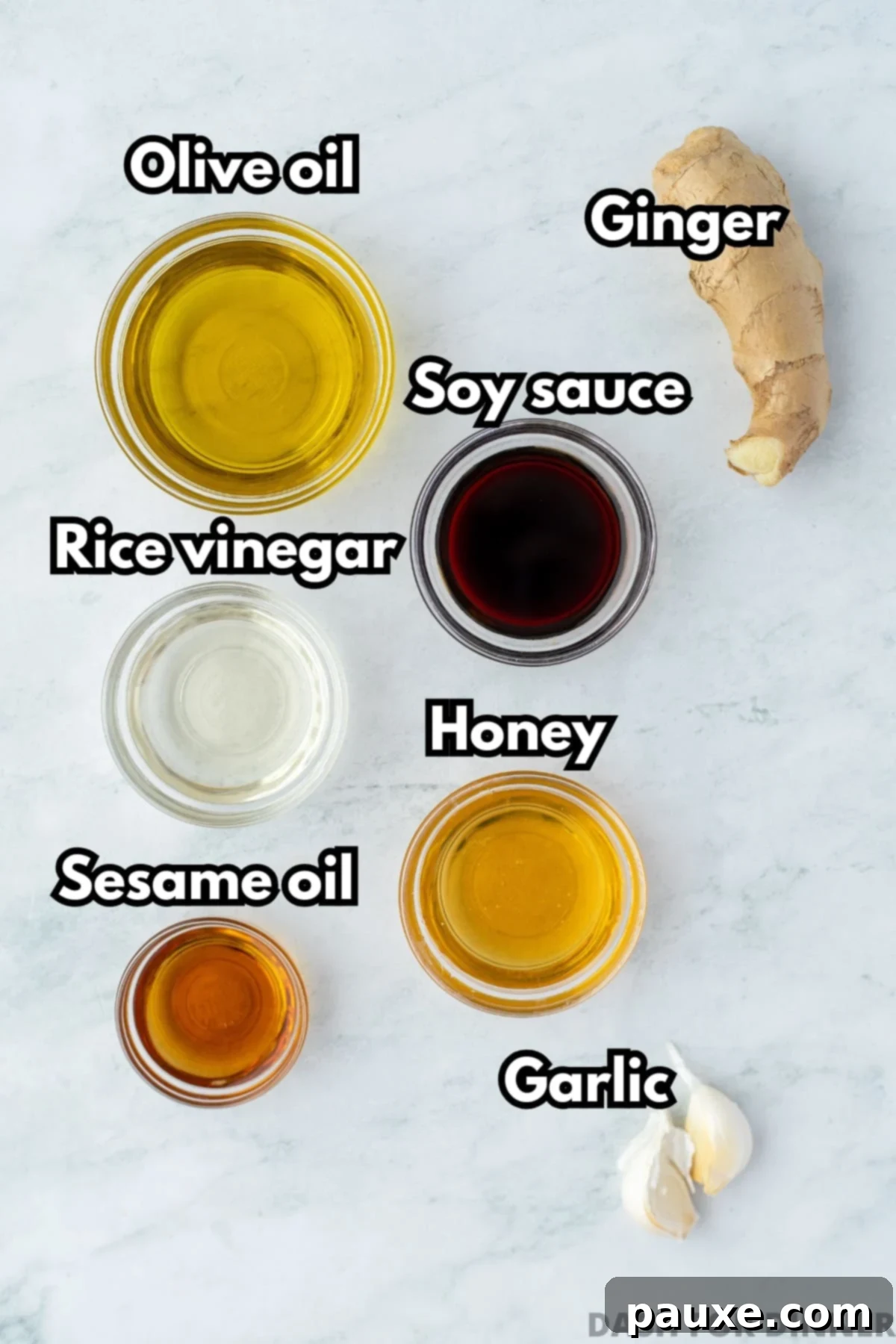 The ingredients needed to make sesame ginger dressing, including olive oil, sesame oil, soy sauce, ginger, and garlic.