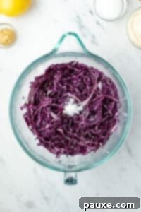 Fresh Israeli Cabbage Slaw 13 A large glass bowl filled with shredded red cabbage.