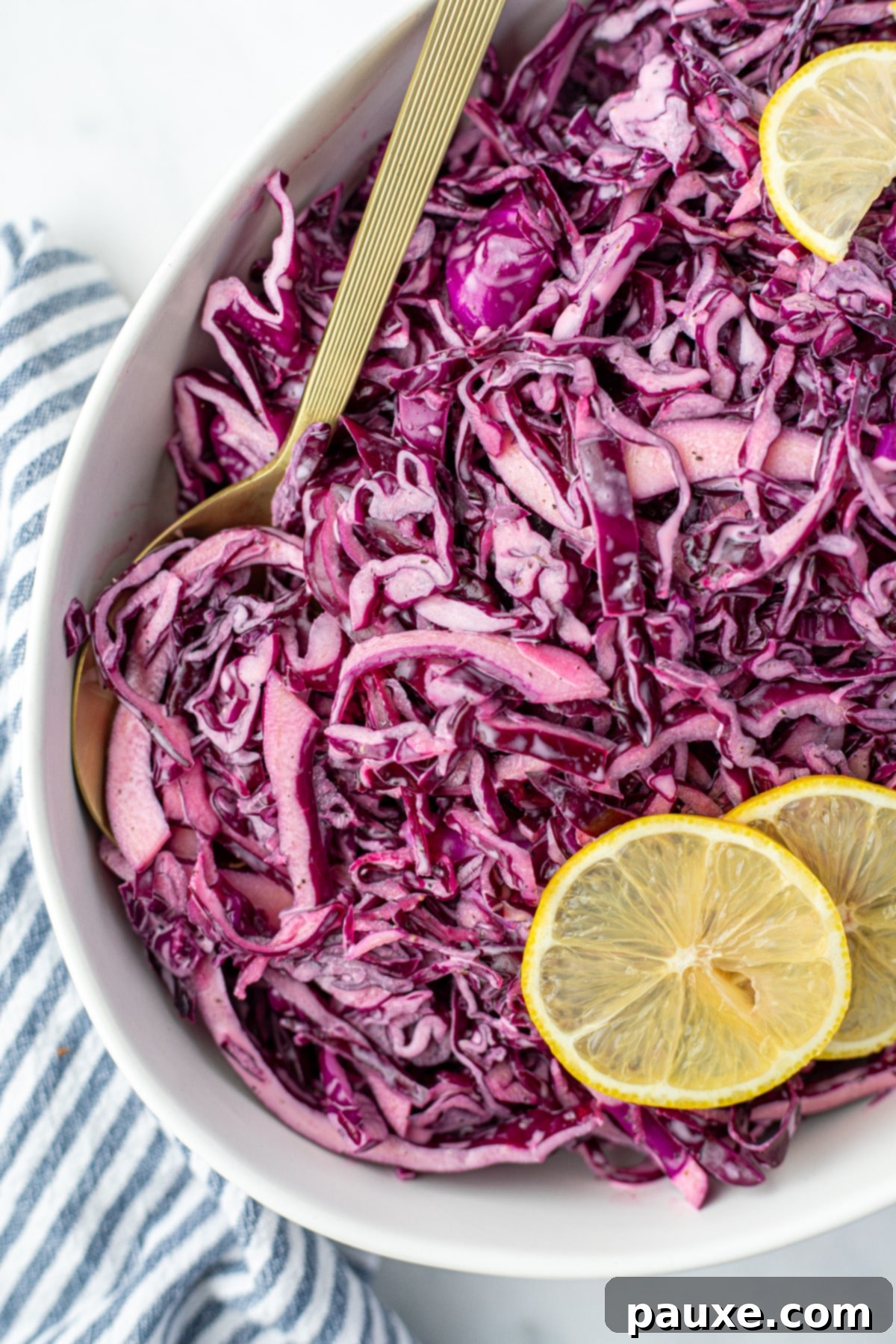 Fresh Israeli Cabbage Slaw 4 A spoon taking a generous portion of red cabbage salad from a large, elegant bowl, highlighting its crisp texture and appealing color.