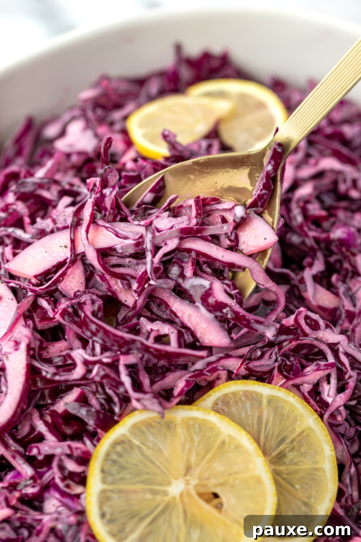 Fresh Israeli Cabbage Slaw 10 A spoon taking a generous portion of red cabbage salad from a bowl, showcasing the vibrant colors and appealing texture.