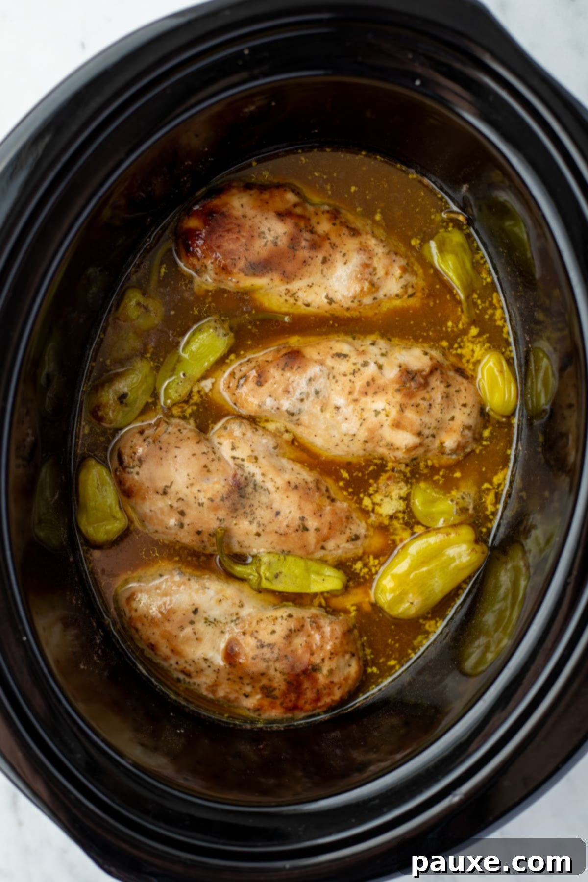 Mississippi Pot Roast Chicken 6 Chicken cooked to perfection in a slow cooker, submerged in a rich, savory sauce with pepperoncini peppers.