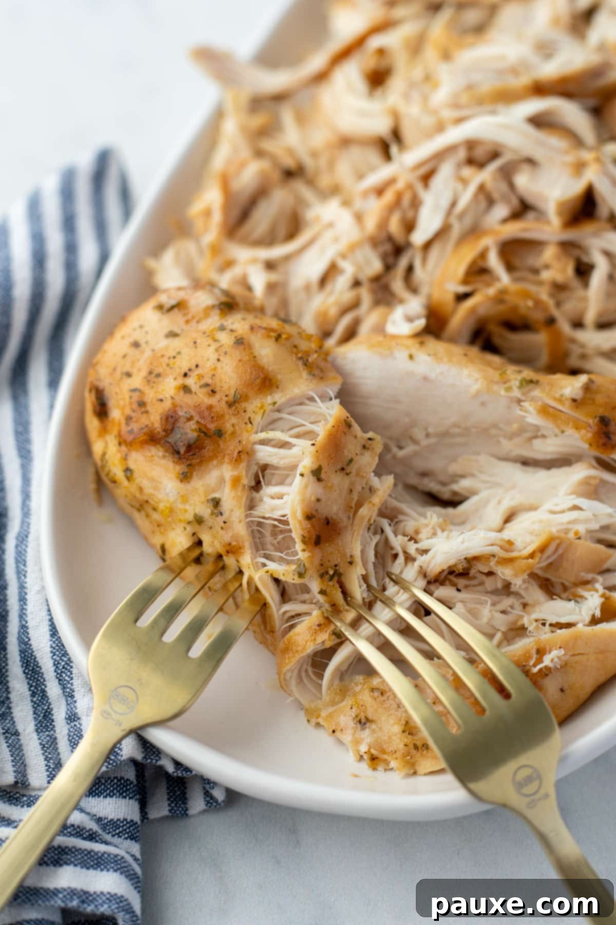 Mississippi Pot Roast Chicken 7 Shredding tender, cooked chicken on a plate using two forks.