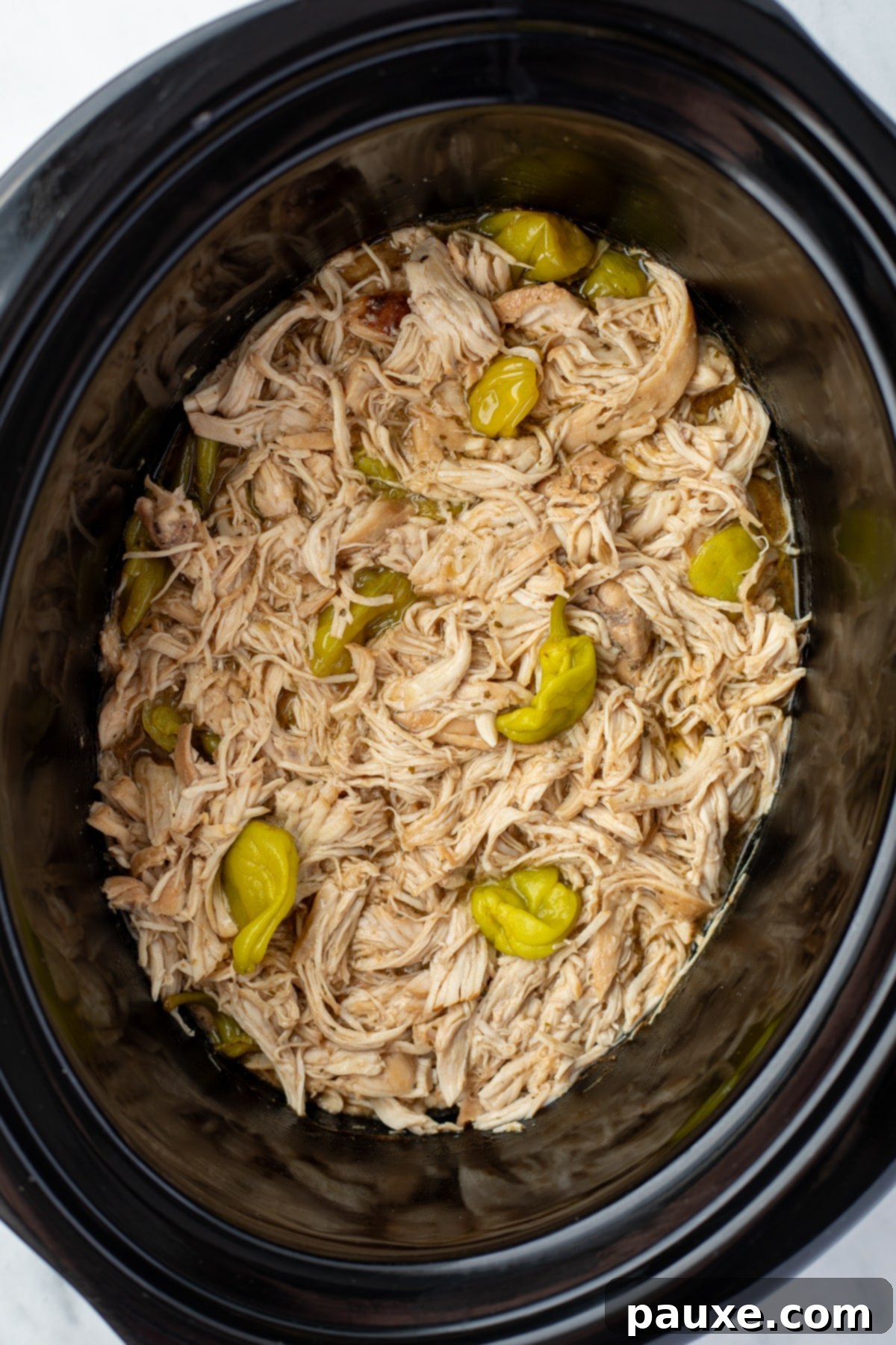 Mississippi Pot Roast Chicken 8 A slow cooker filled with perfectly shredded, juicy Mississippi chicken, ready to be served.
