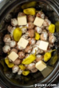 Dixie Glazed Meatballs 12 A slow cooker filled with meatballs, pepperoncini peppers, and butter.