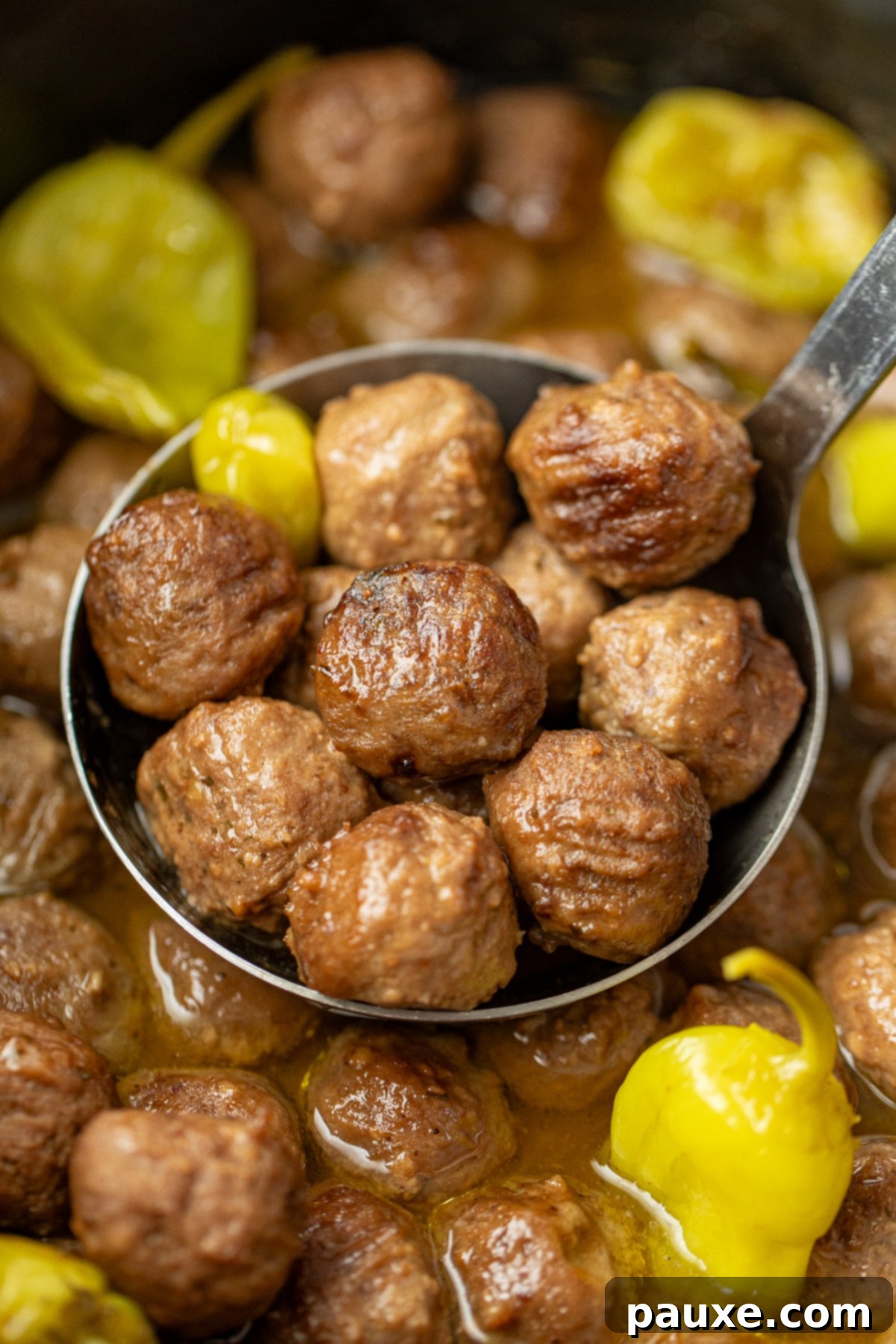 Dixie Glazed Meatballs 7 Scooping a ladle full of cooked meatballs from a large crock.