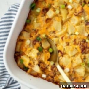 Deep South Midnight Spuds 9 A spoon taking a portion of potato casserole from a baking dish.