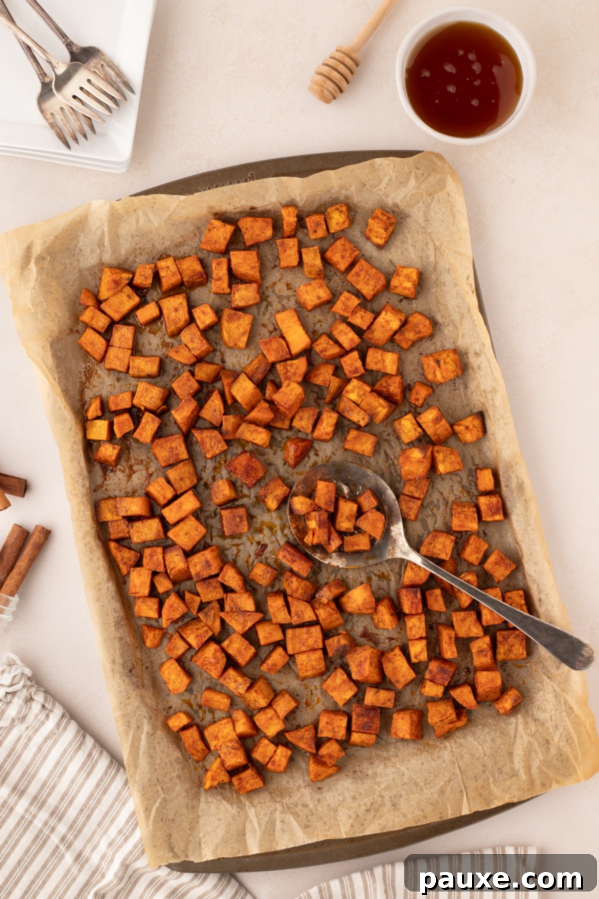 Golden Roasted Sweet Potato Bites 2 A baking sheet filled with golden, crispy roasted sweet potato cubes.