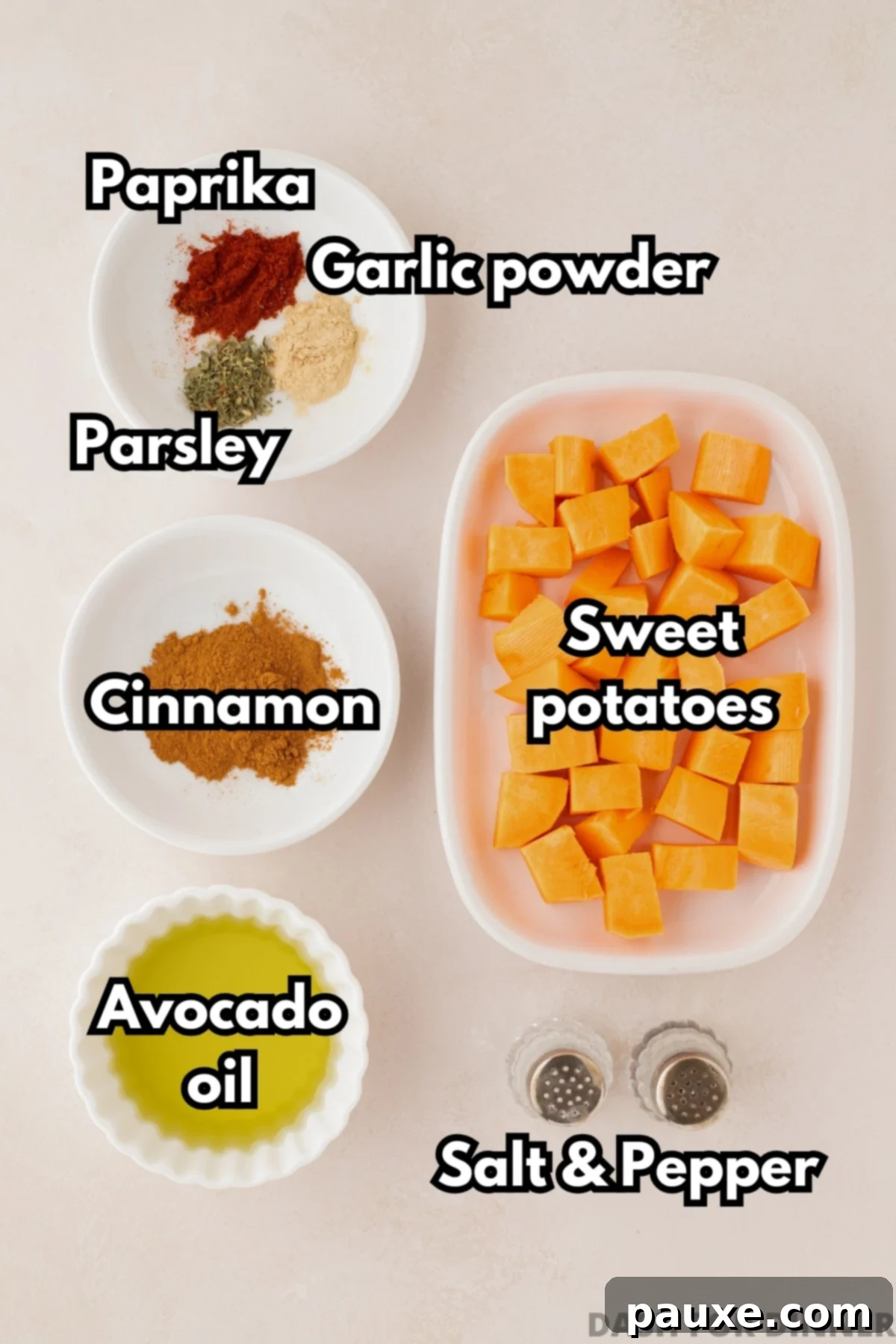 Golden Roasted Sweet Potato Bites 3 A bowl of uniformly cubed sweet potatoes, surrounded by small bowls of various seasonings, oil, and salt and pepper.