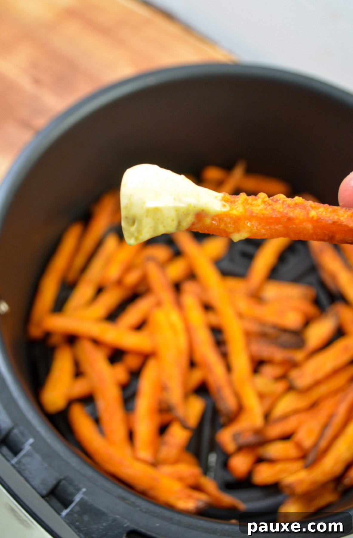 Crispy Air Fryer Sweet Potato Fries 2 Air fryer frozen sweet potato fries in a basket, freshly cooked and golden.