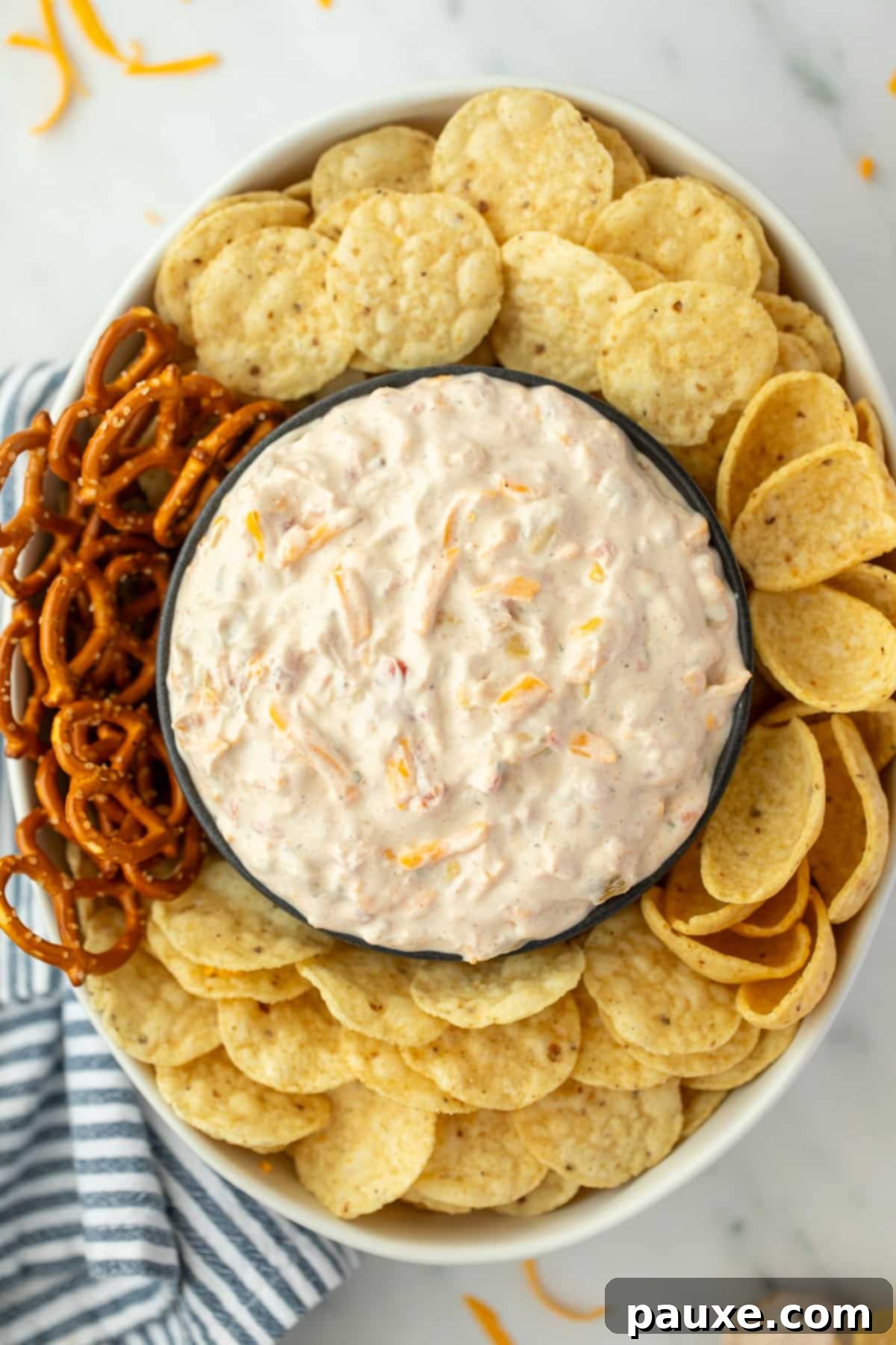An oval dish filled with tortilla chips, with a bowl of creamy dip in the center.