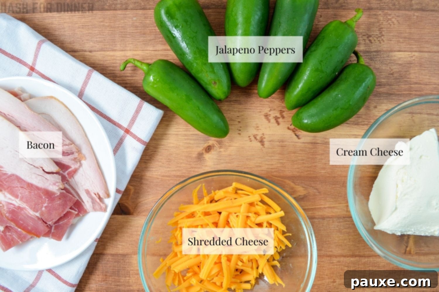 Crispy Air-Fried Jalapeño Poppers 3 A flat lay image displaying the four simple ingredients needed to make air fryer jalapeno poppers: fresh green jalapenos, a block of cheese, softened cream cheese, and strips of bacon.