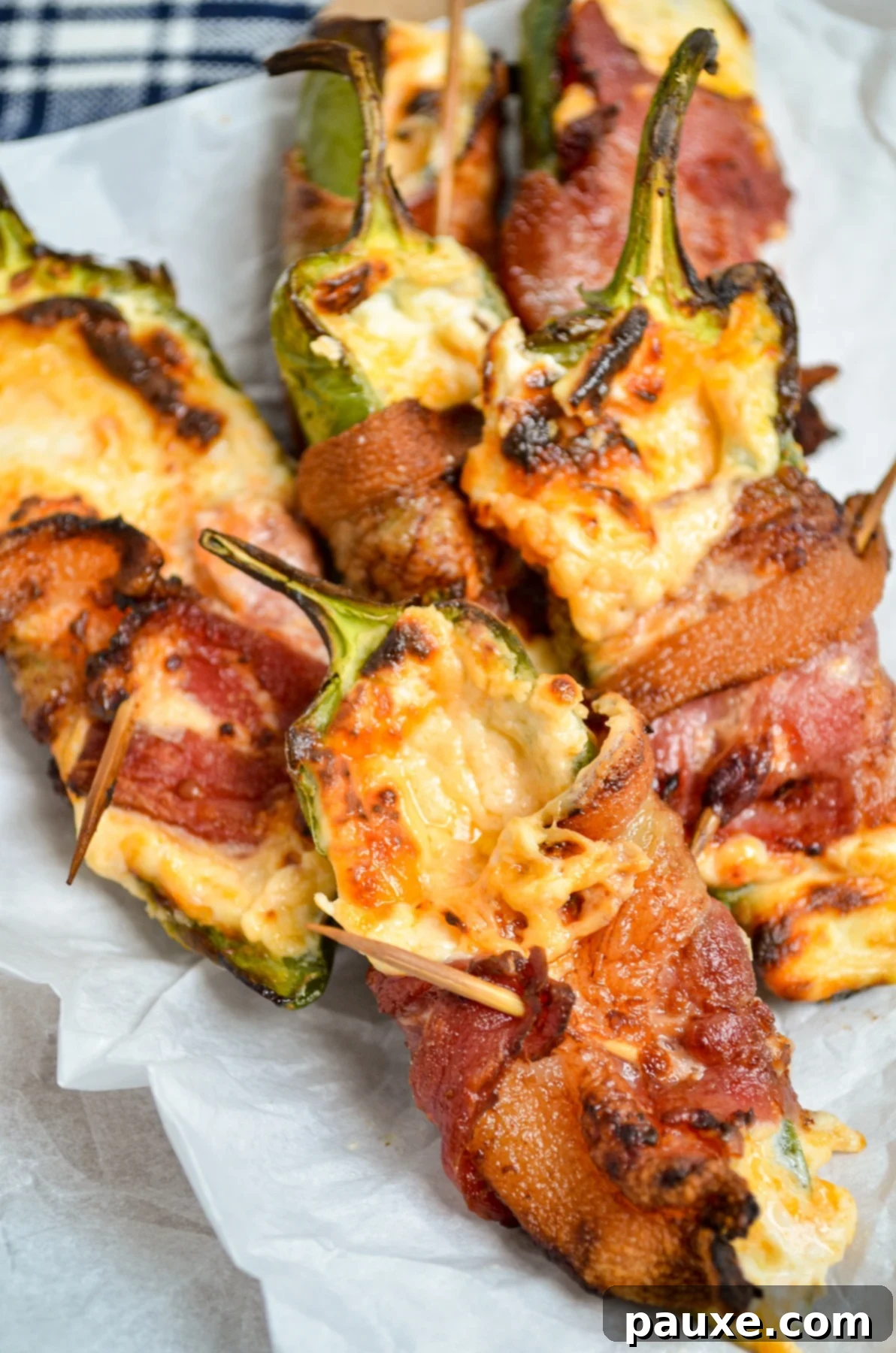 Crispy Air-Fried Jalapeño Poppers 7 A tantalizing plate of freshly cooked bacon-wrapped jalapeno poppers from the air fryer, showcasing their golden-brown bacon and melted cheese.