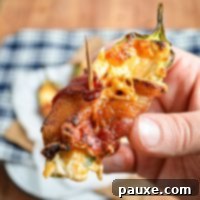 Crispy Air-Fried Jalapeño Poppers 8 A hand holding up a homemade bacon wrapped jalapeno popper