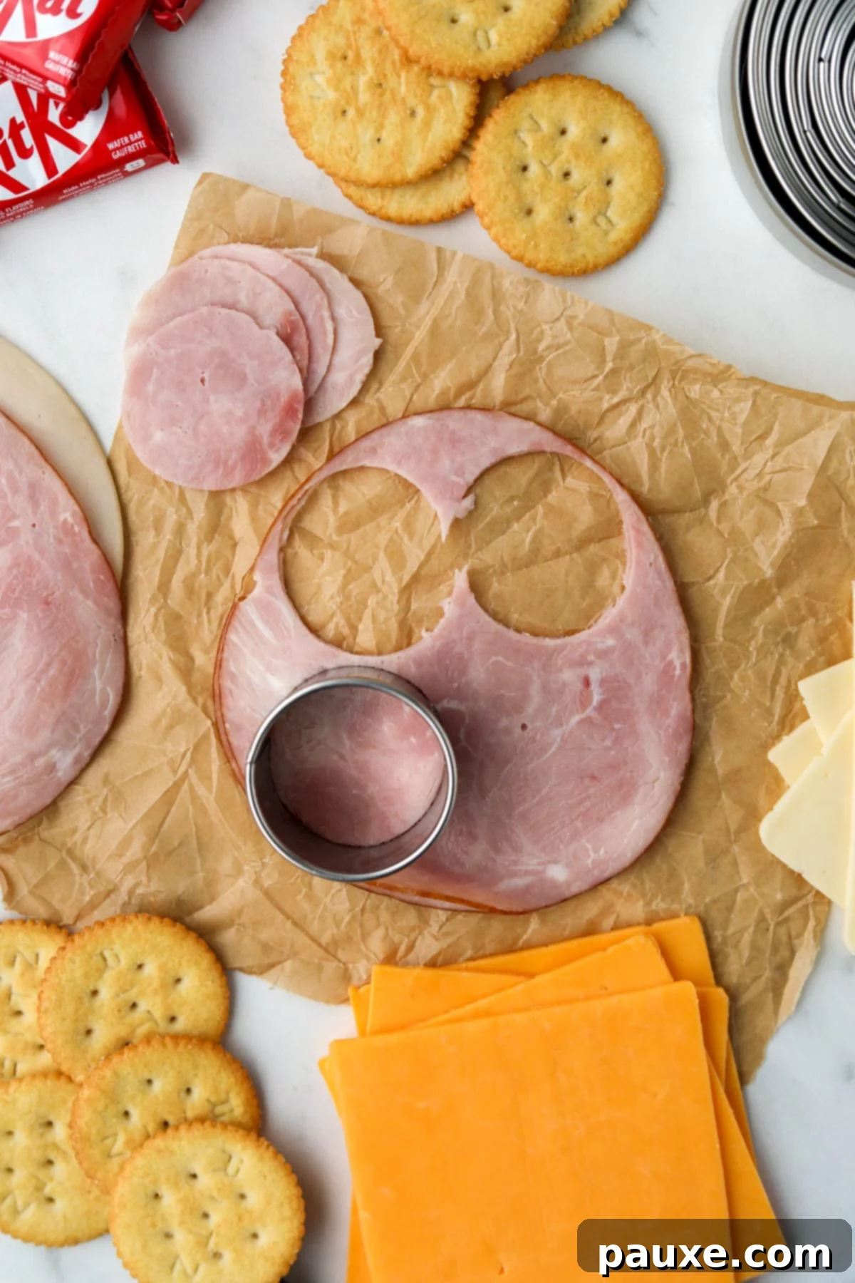 Craft-Your-Own Lunch Kits 4 A hand using a circular cutter to precisely slice deli meat into neat, uniform rounds, perfect for homemade lunchables.