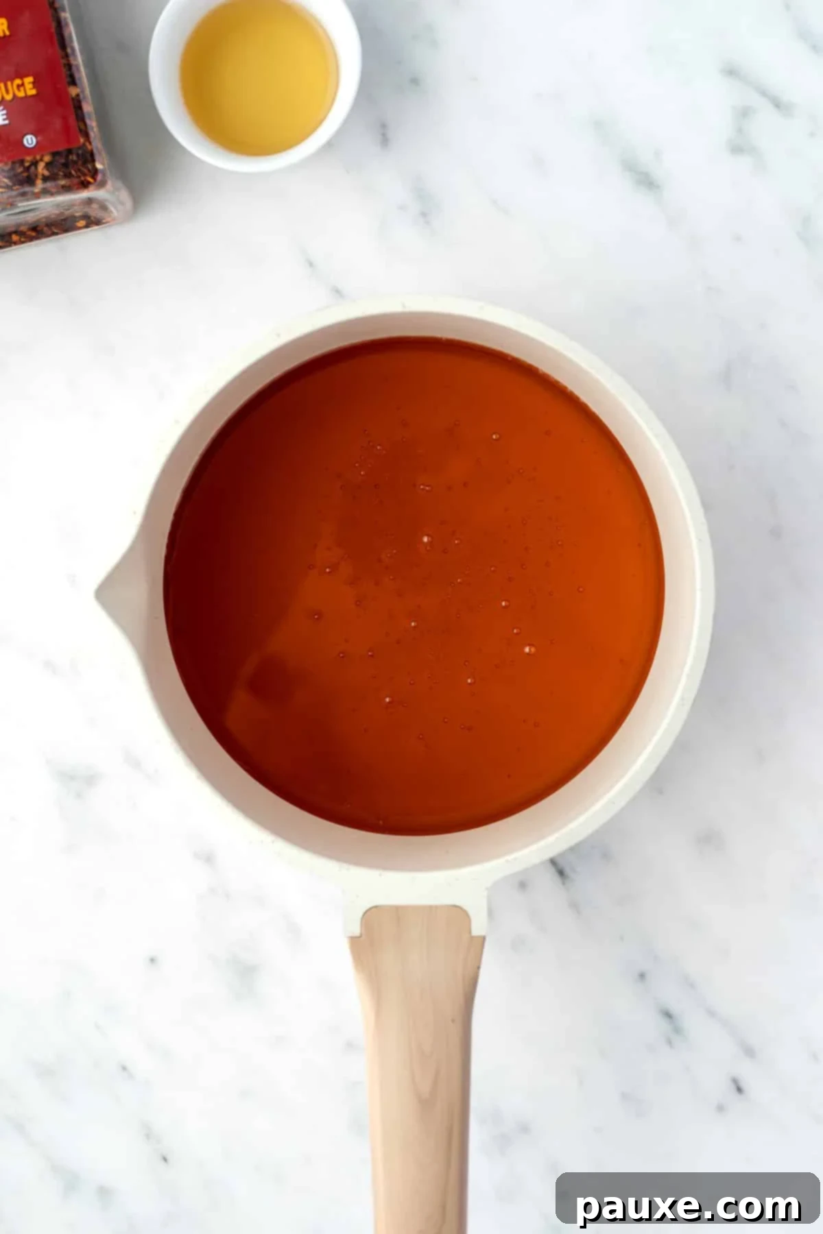 Crafting Homemade Hot Honey 4 A small saucepan with honey inside, warming gently on the stovetop.