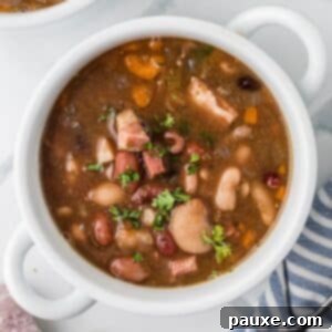 Hearty Fifteen-Bean Soup 9 A bowl of soup filled with juicy beans and ham chunks, a perfect homemade meal.