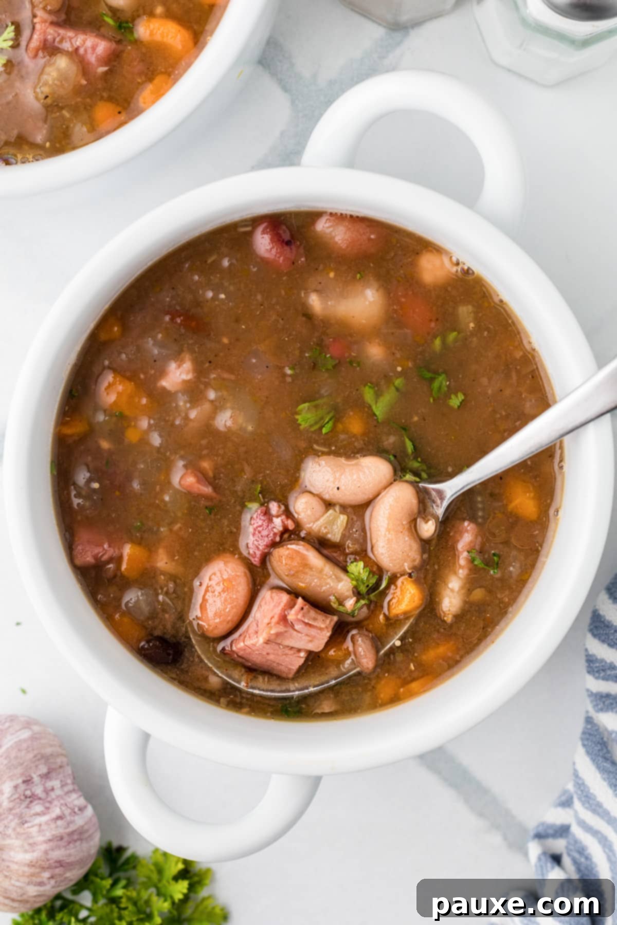Hearty Fifteen-Bean Soup 8 A spoon in a bowl of soup, showing the texture and ingredients of the ham and bean soup.