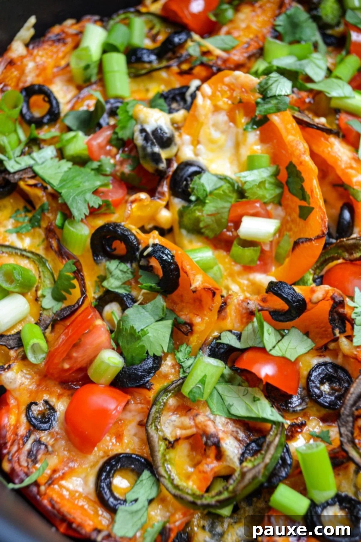 Loaded Air Fryer Mini Bell Pepper Nachos 3 Close-up of an air fryer basket filled with bubbly, melted Air Fryer Mini Pepper Nachos.